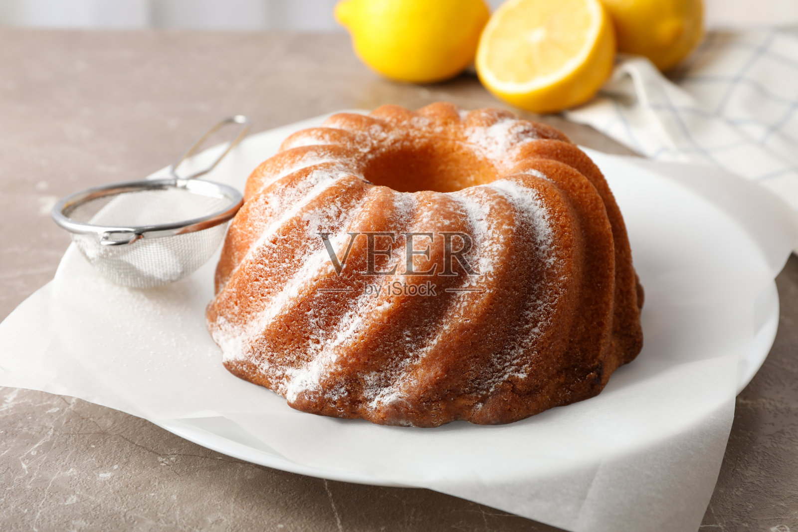 蛋糕和粉糖在灰色的桌子上，靠近照片摄影图片