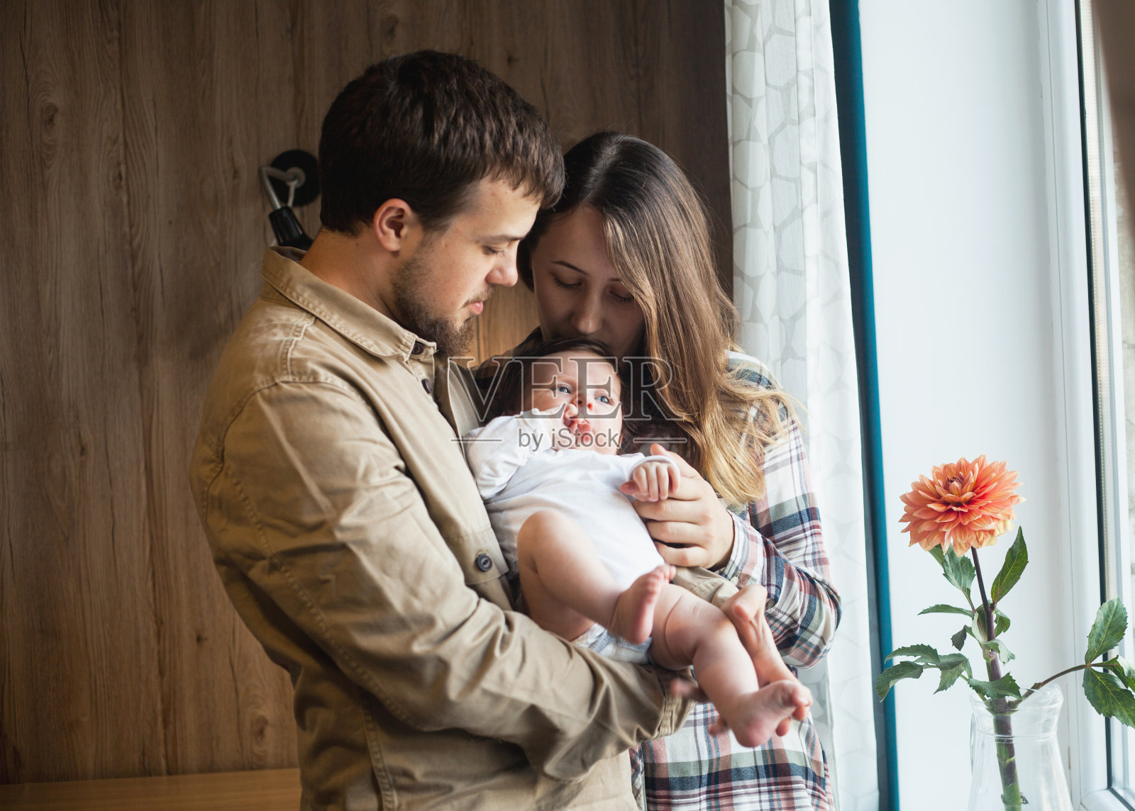可爱的家庭，年轻的父母和婴儿在家照片摄影图片