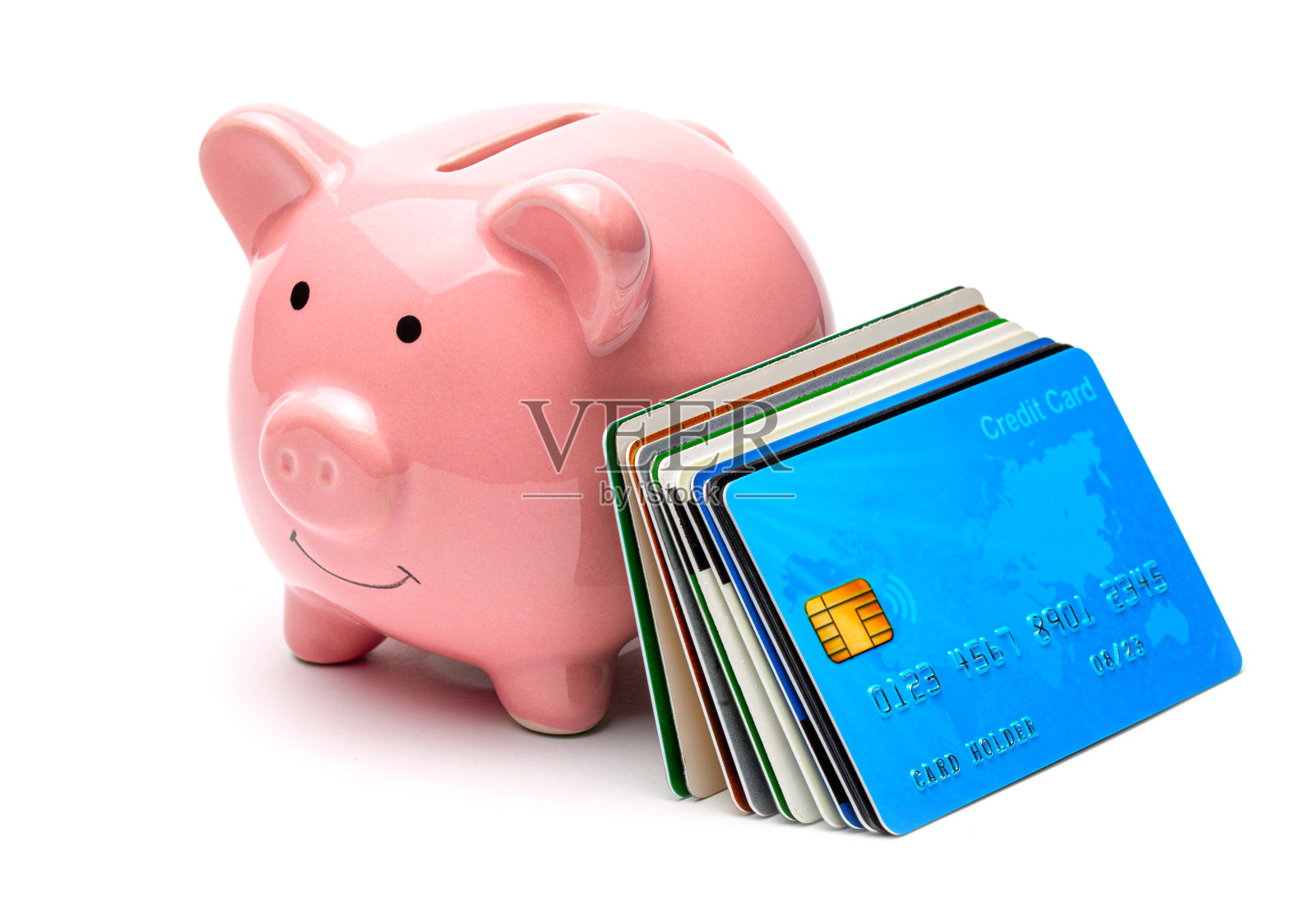 粉红色的储蓄罐和信用卡在白色的背景孤立的一堆。如何用信用卡省钱照片摄影图片