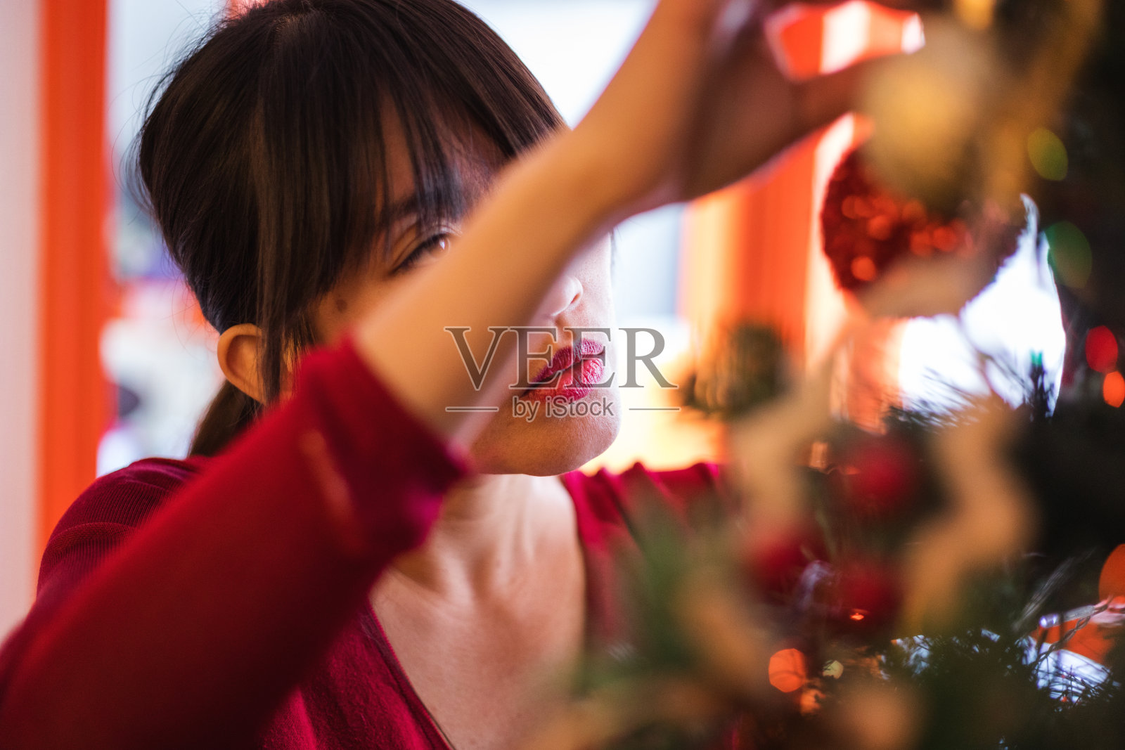 美丽的亚洲女人在家里装饰圣诞树，真实的人照片摄影图片