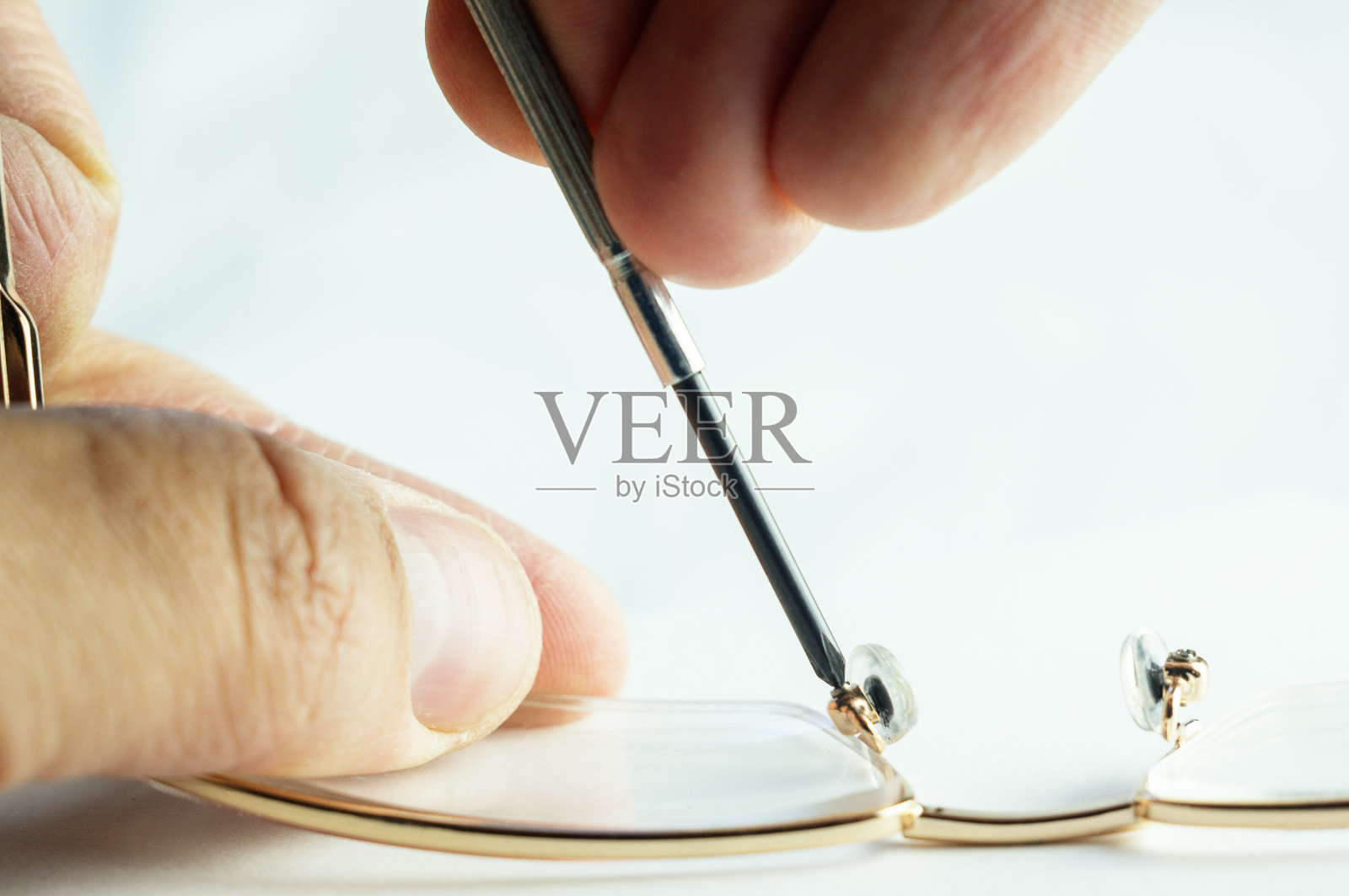 修理破碎的玻璃，用螺丝刀工作，拧紧螺栓照片摄影图片