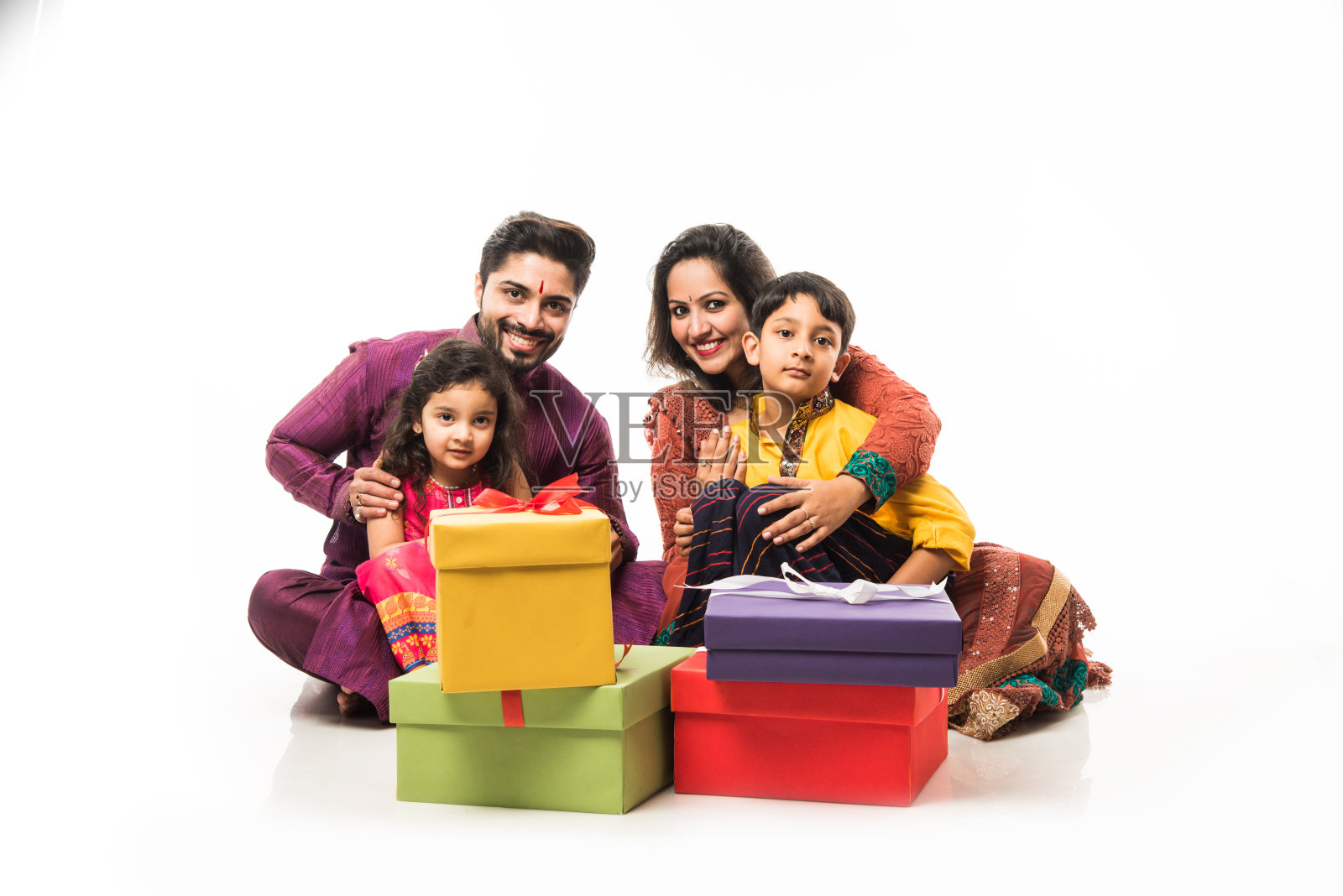 印度四口之家庆祝排灯节与礼盒和diya盘而穿着民族服装照片摄影图片