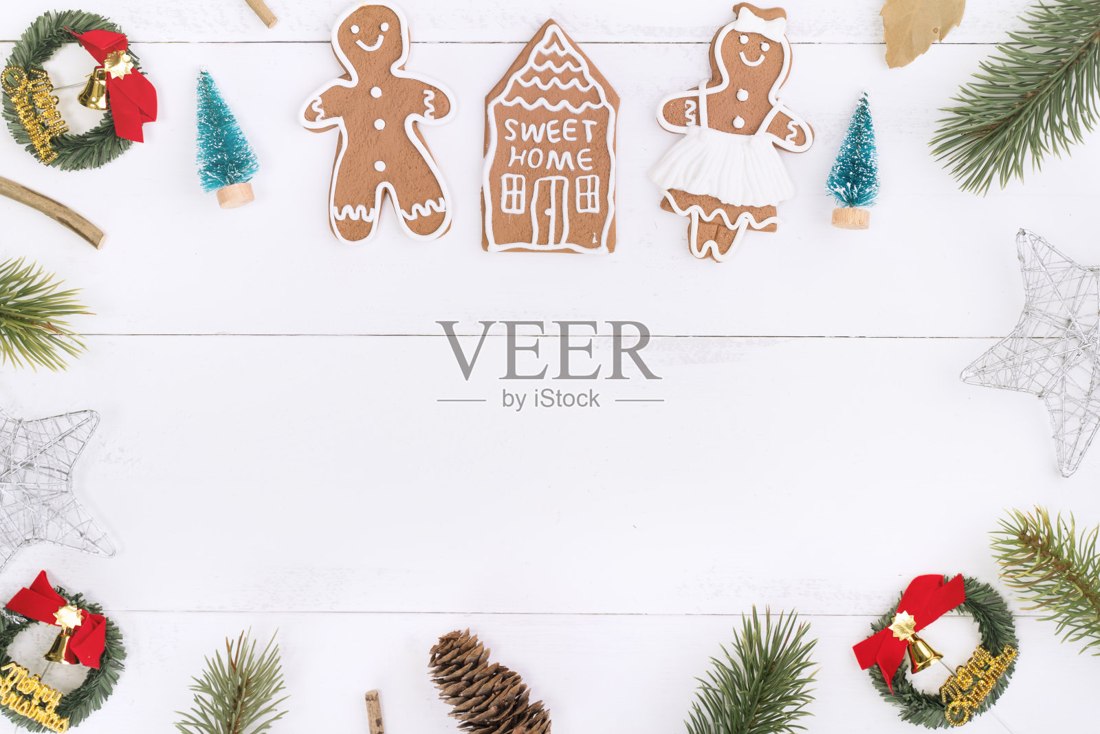 圣诞概念构图装饰物，冷杉树枝花环，姜饼人饼干孤立在白色木桌上。照片摄影图片