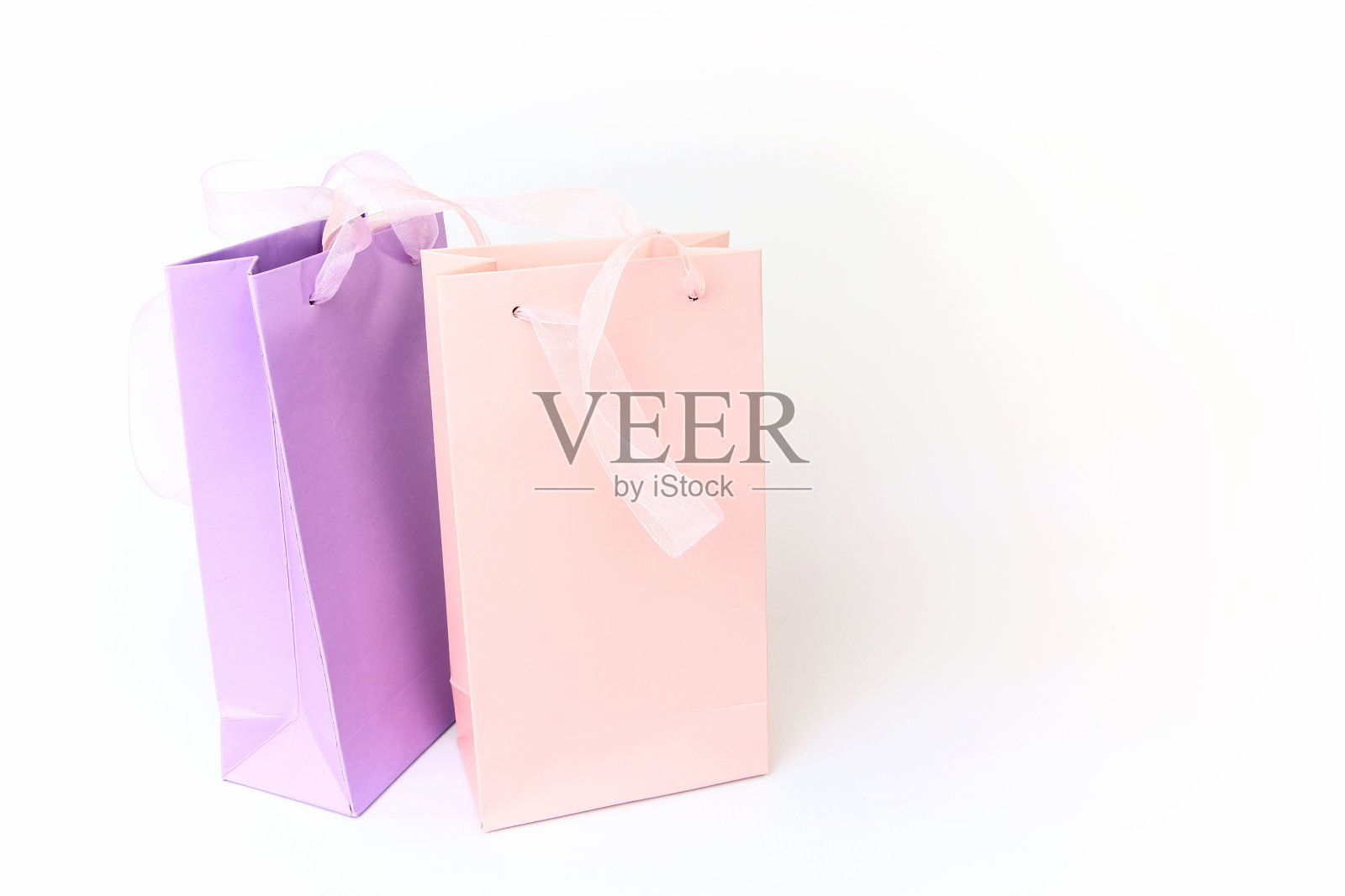 淡粉色和淡紫色购物袋孤立在白色照片摄影图片
