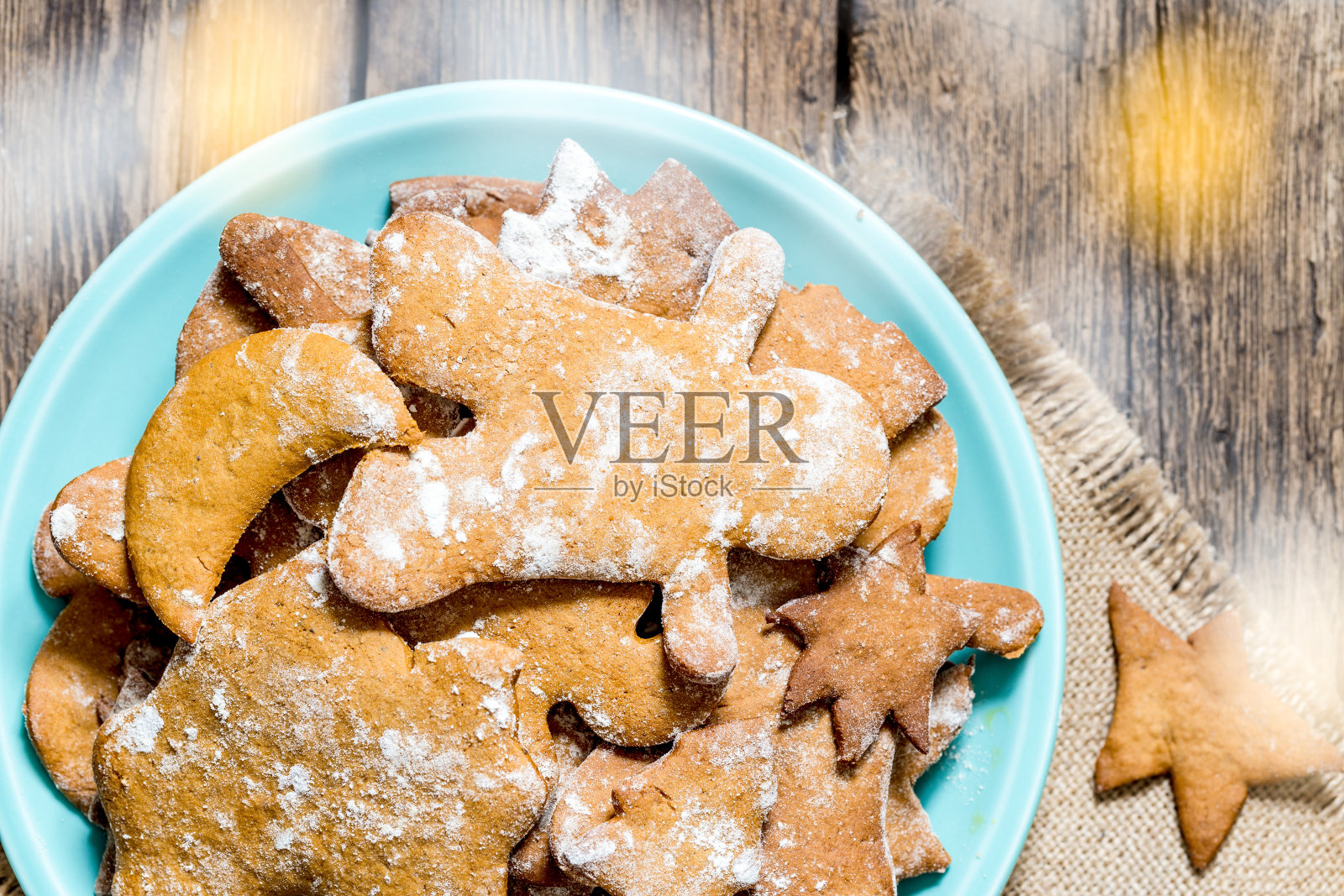 自制的圣诞装饰姜饼人饼干放在古老的乡村木桌上的盘子里。平的观点。照片摄影图片