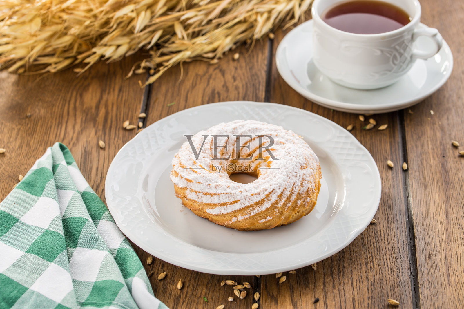 奶油泡芙圈和糖粉泡芙糕点放在木桌上照片摄影图片