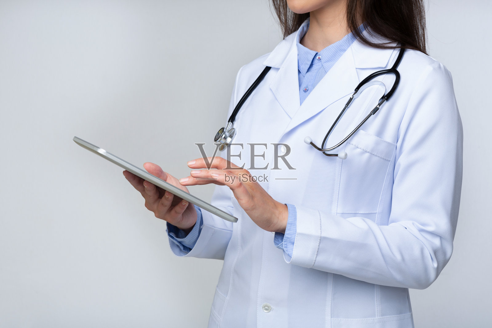 不认识的女医生使用平板电脑在工作室，裁剪照片摄影图片