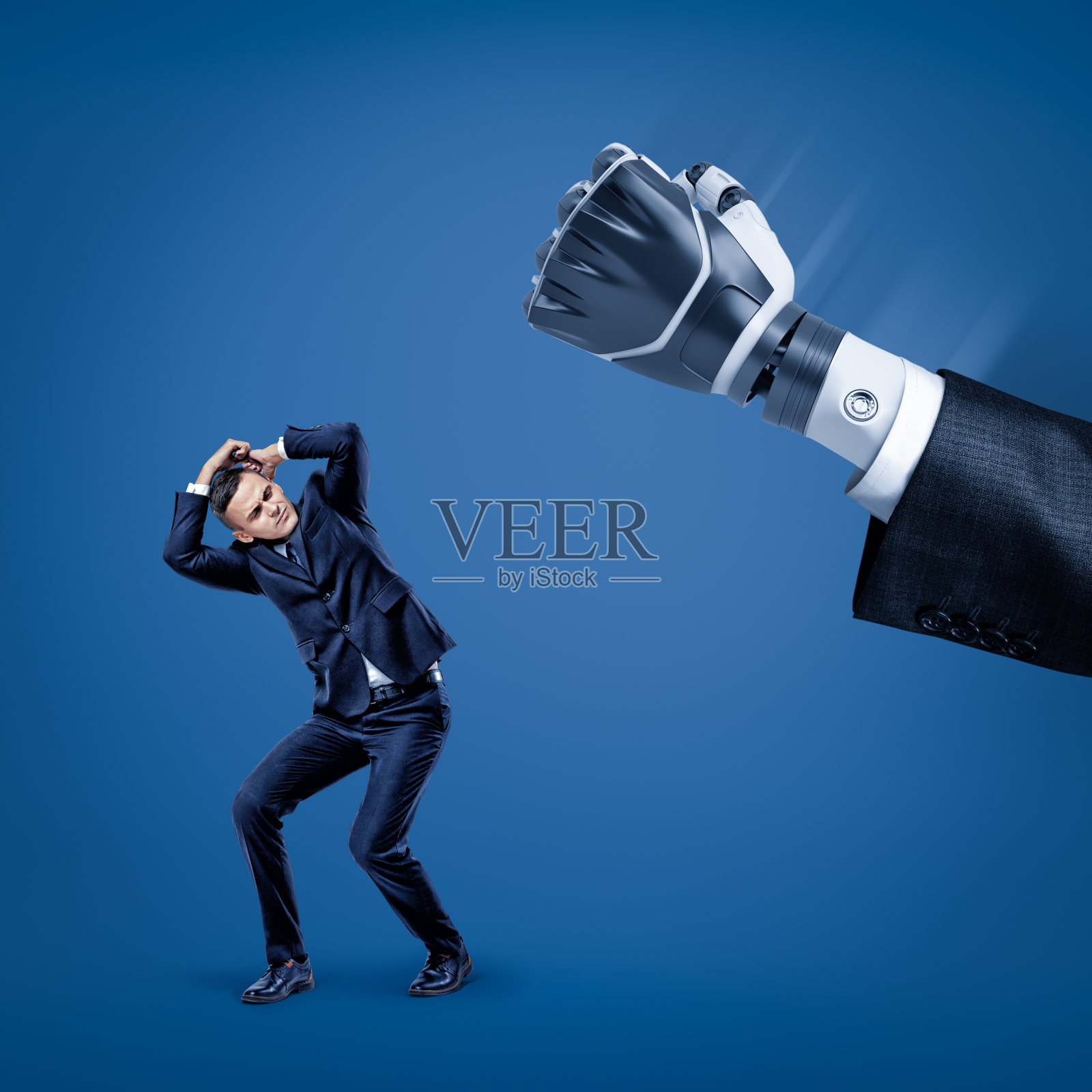 商人用双手蒙住头，以保护自己免受西装里的大机器人手的伤害。照片摄影图片