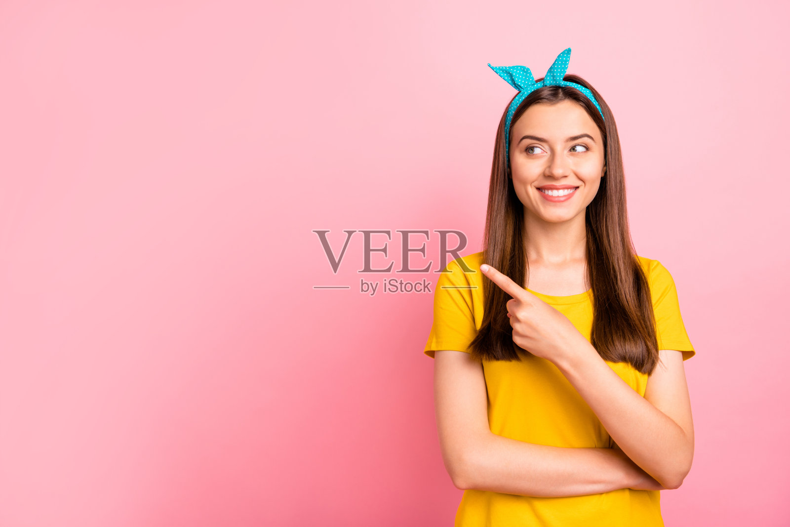 肖像迷人的推广指着拷贝空间看穿着黄色t恤孤立在粉红色的背景照片摄影图片