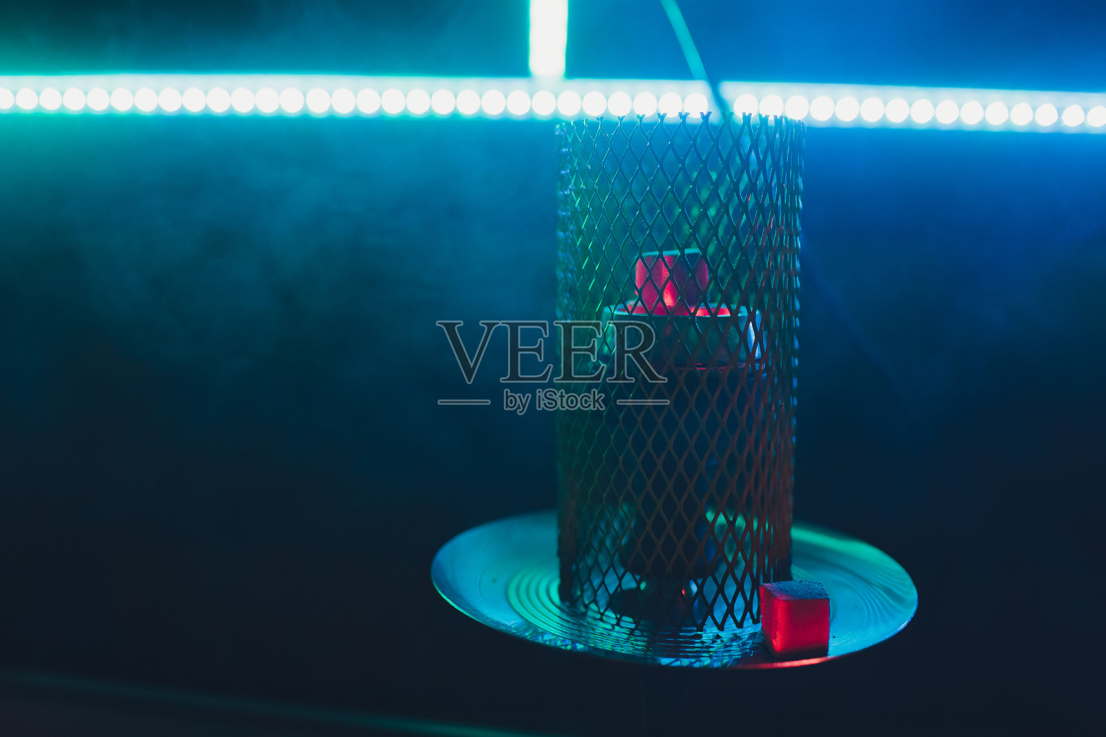 水烟和烧红的煤。火花从呼吸。椰炭和水烟的现代水烟。水烟和煤的火花。照片摄影图片