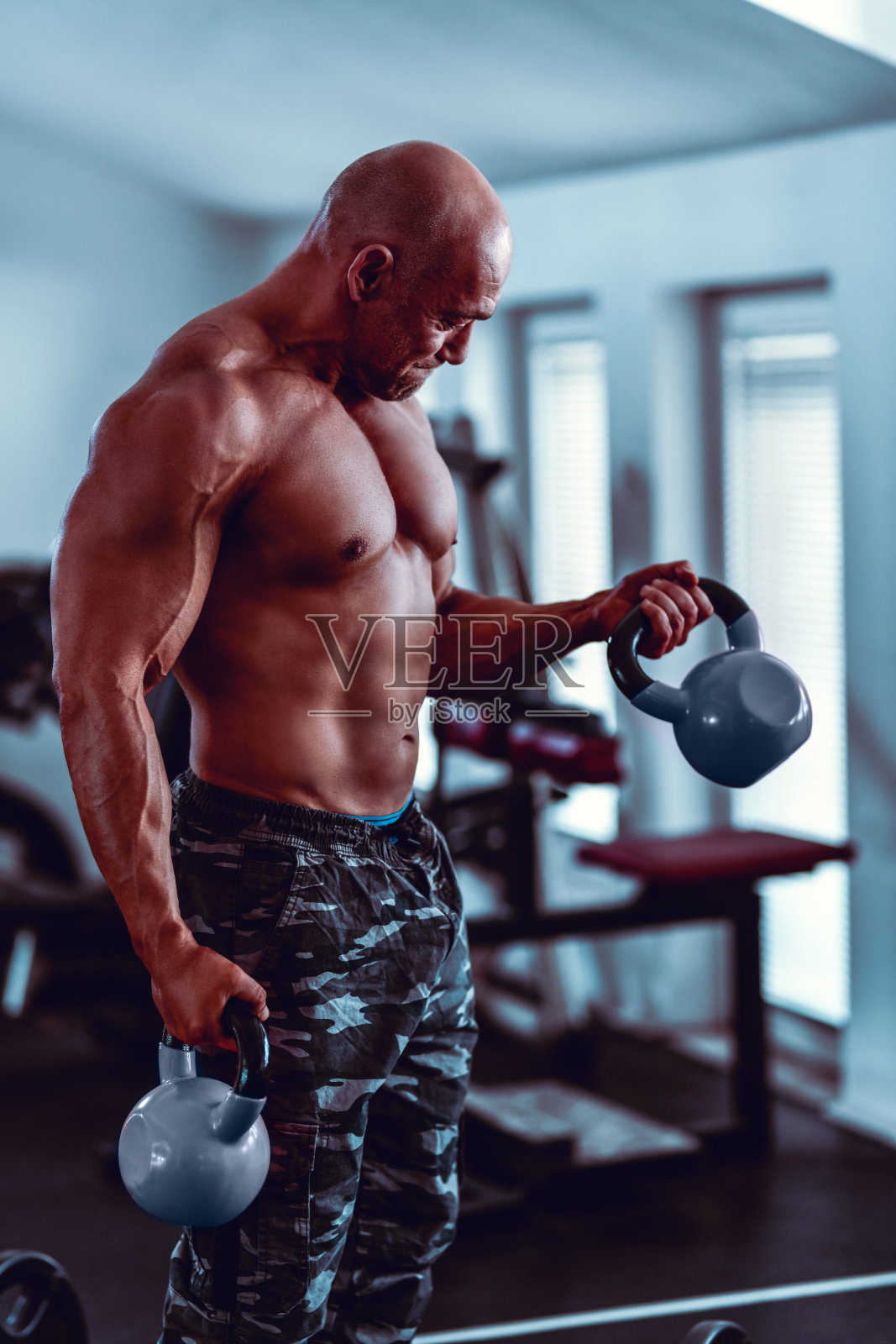 成熟的男性健美运动员在壶铃训练中给予他最好的照片摄影图片