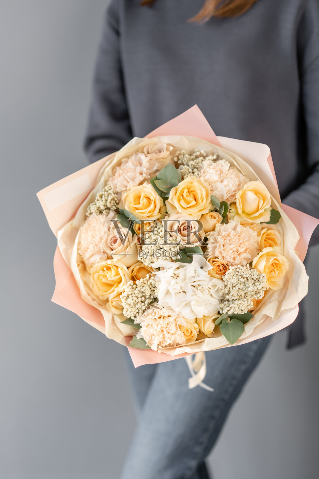 女人手里捧着一束美丽的混合鲜花。花店花匠的工作。新鲜切花。照片摄影图片