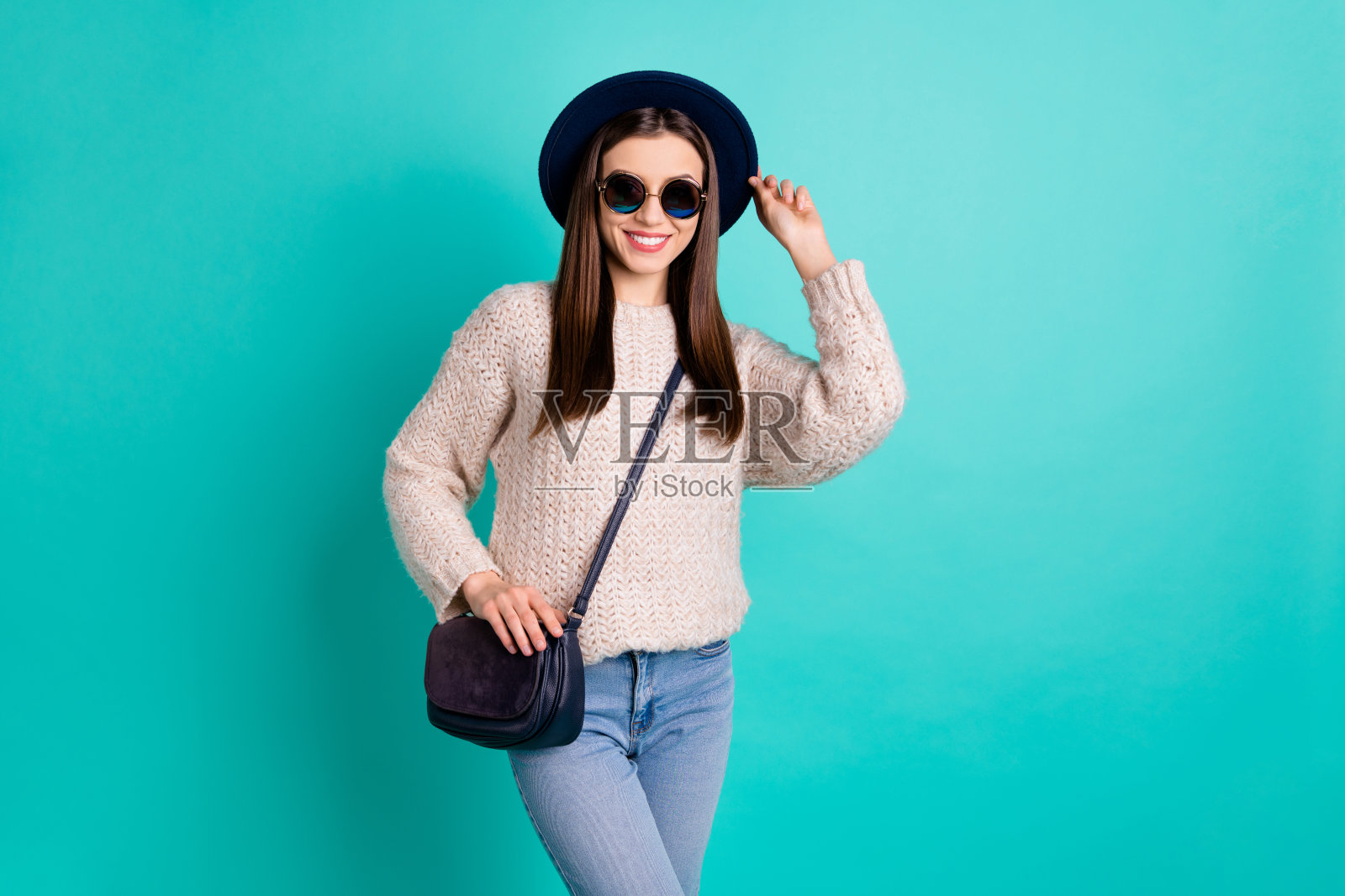 画像满意可爱的女士准备有乐趣的自由时间穿羊毛套衫牛仔牛仔裤孤立在蓝绿色的背景照片摄影图片