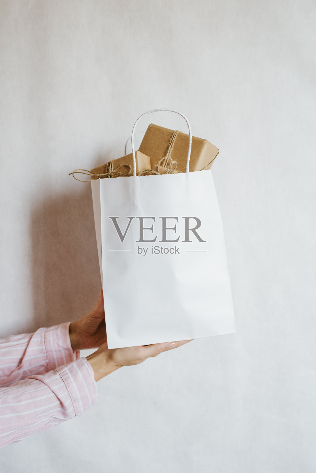 手里拿着许多礼品盒的女人。节日礼物。盒子与惊喜。快乐的庆祝活动。牛皮纸包装。包装纸和丝带。女性的手与盒子特写。祝贺照片摄影图片