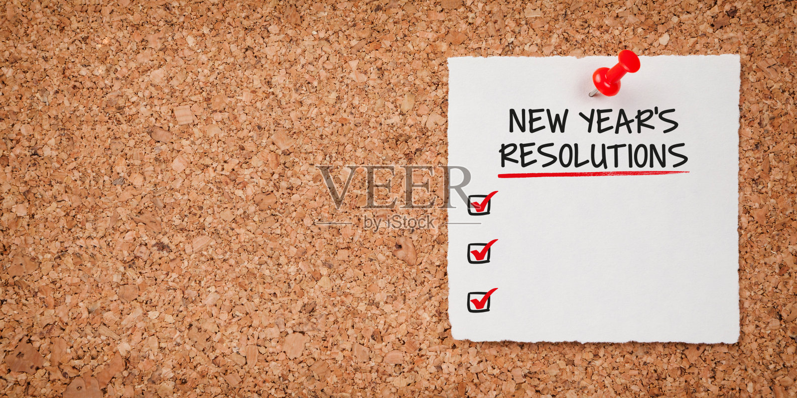 带有新年决心清单的白色便签和软木板上的红色图钉照片摄影图片