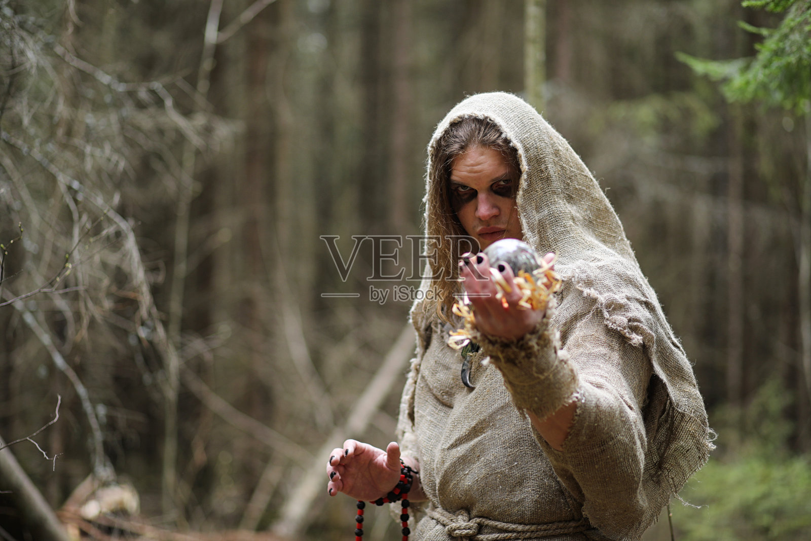 一个穿着法衣的男人在黑暗的森林里举行仪式照片摄影图片