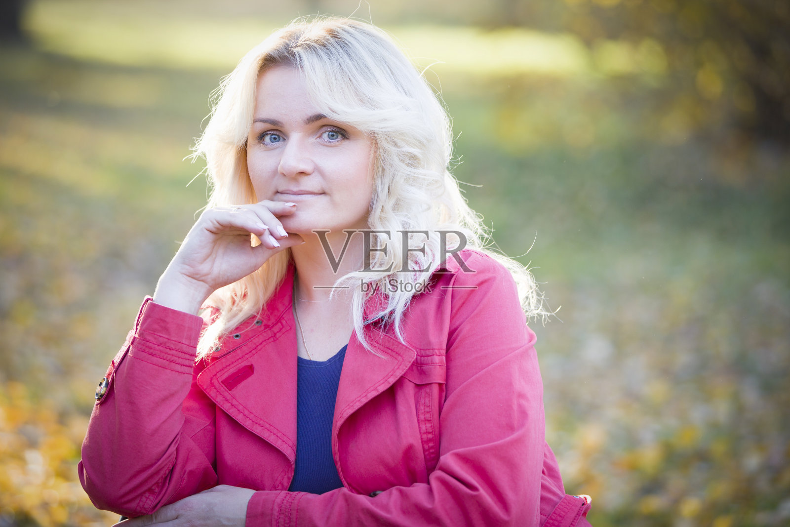 美丽的中年女人在街上。秋日背景上的纯金色照片摄影图片