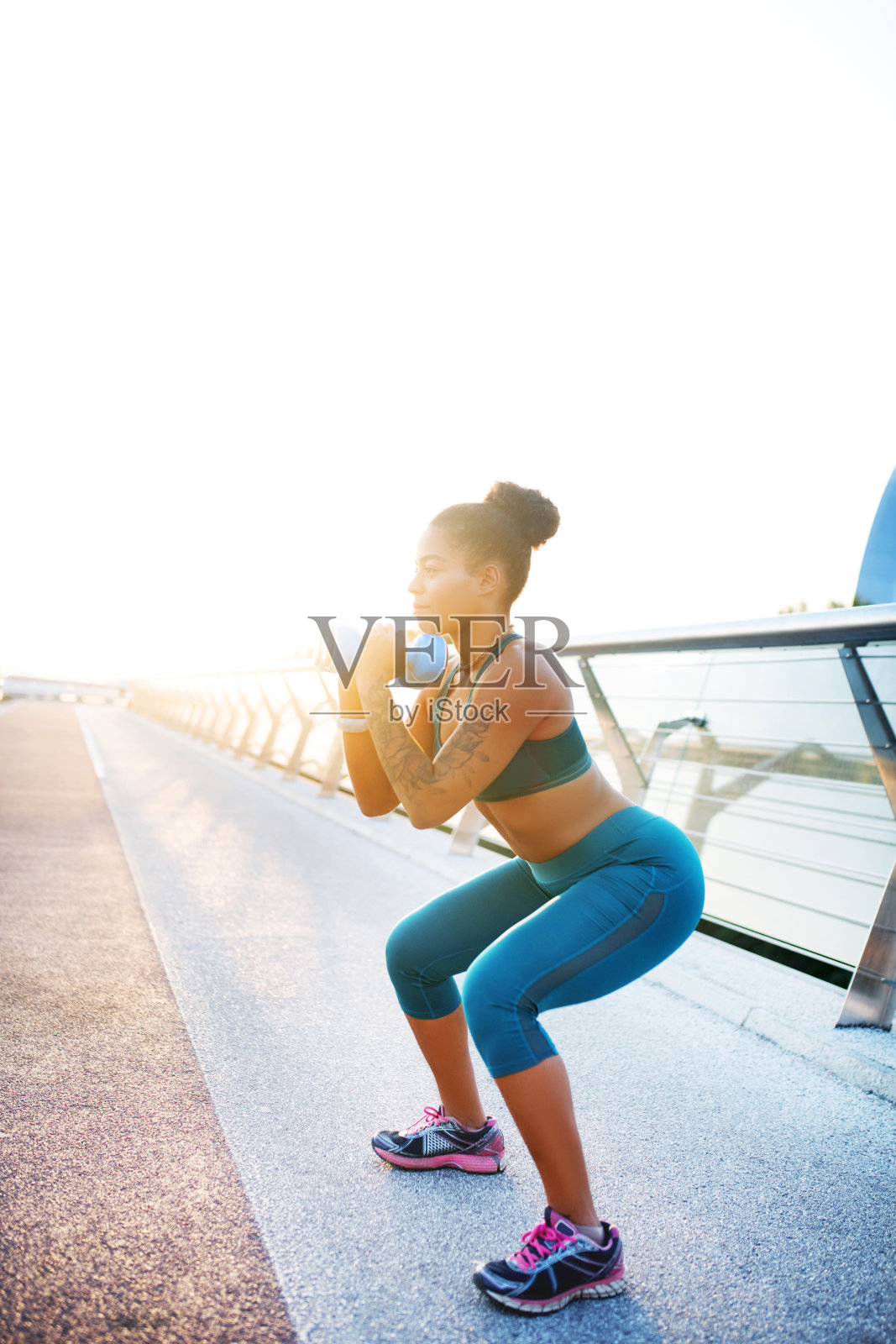 深色皮肤的女人拿着哑铃做仰卧起坐照片摄影图片