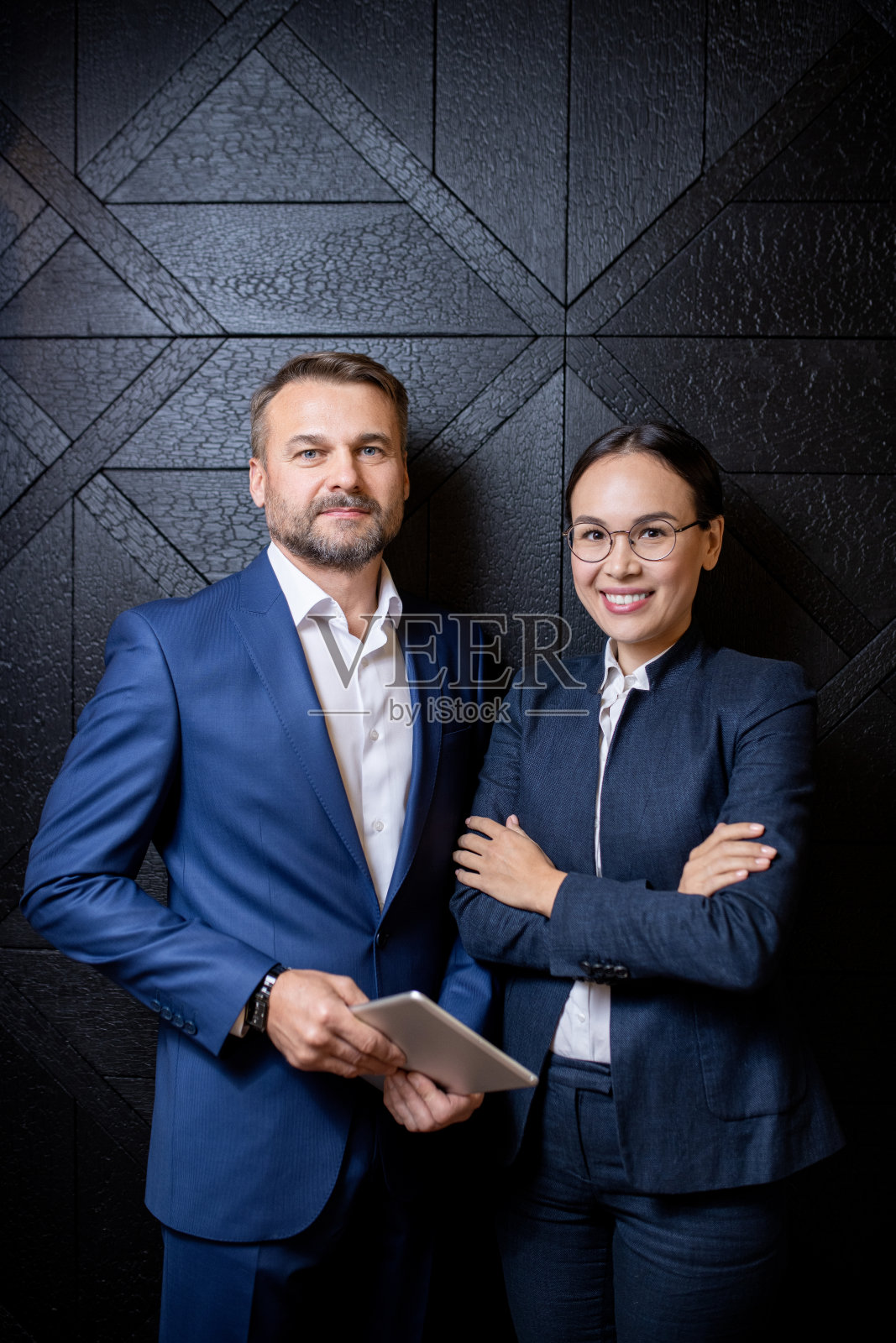 快乐年轻优雅的女商人和她自信的中年同事照片摄影图片