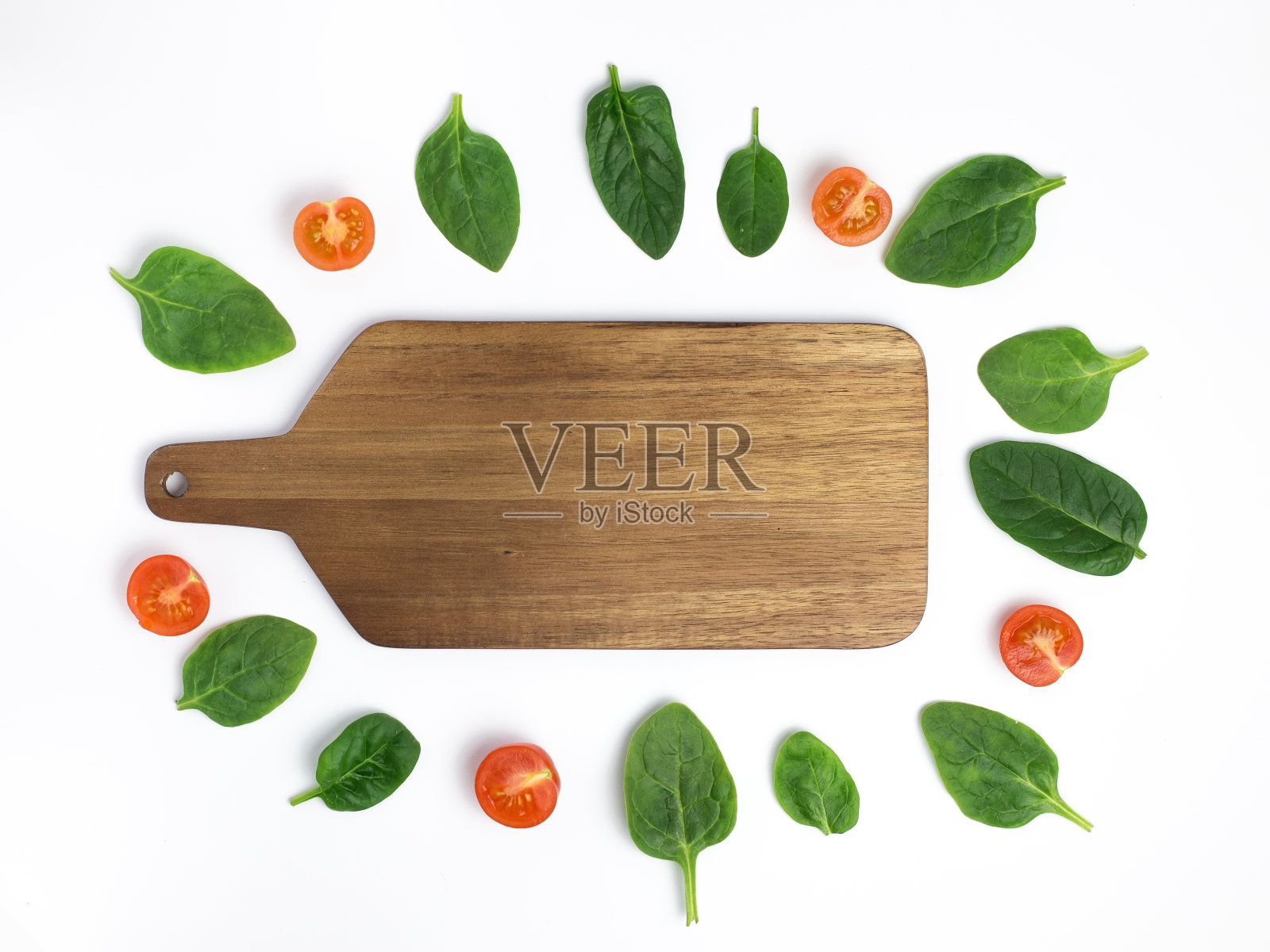 切板与新鲜菠菜叶和樱桃番茄在白色的背景，顶视图与复制空间，模拟照片摄影图片