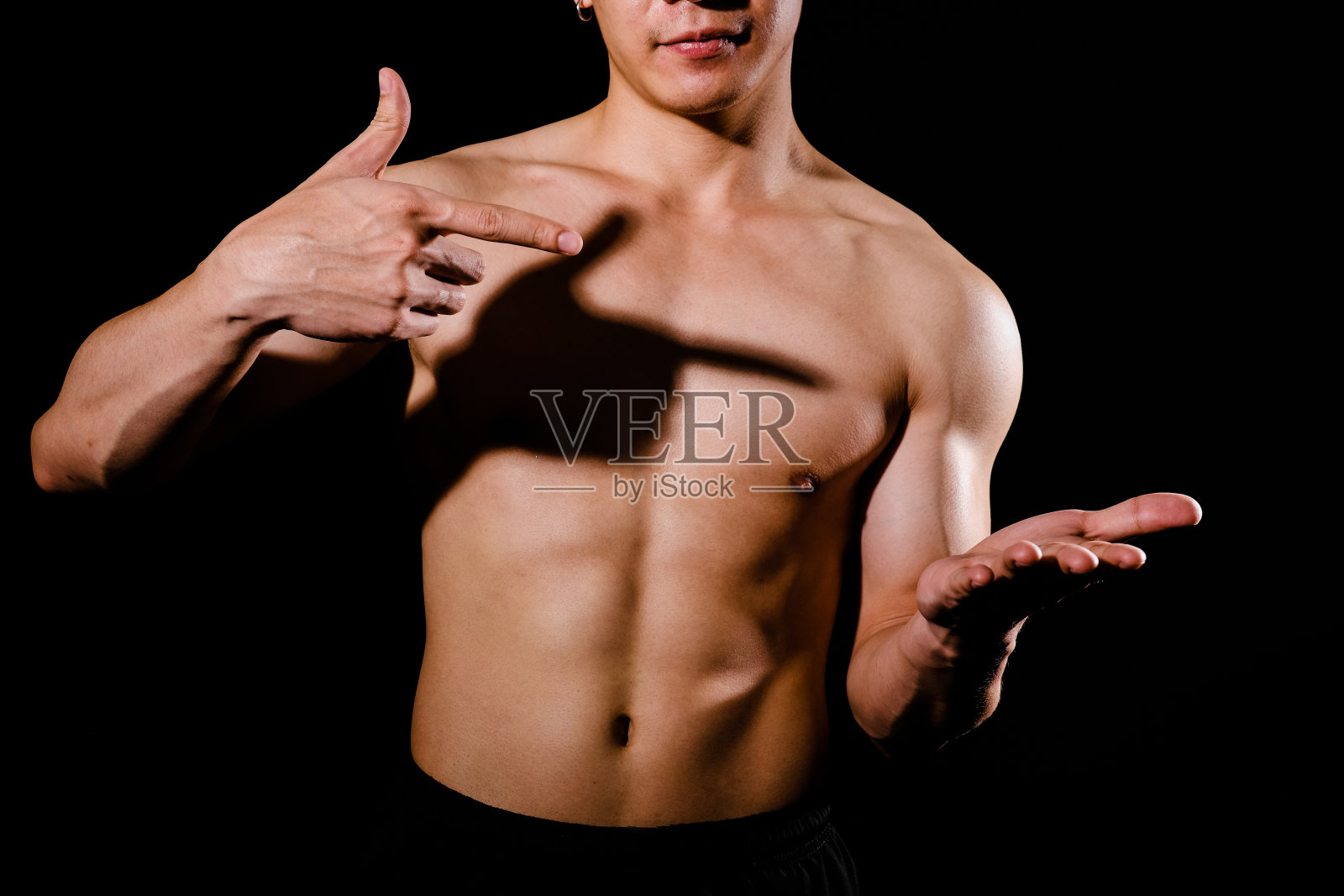 运动员肌肉健美的人与躯干六个腹肌显示拷贝空间。健身运动的概念照片摄影图片