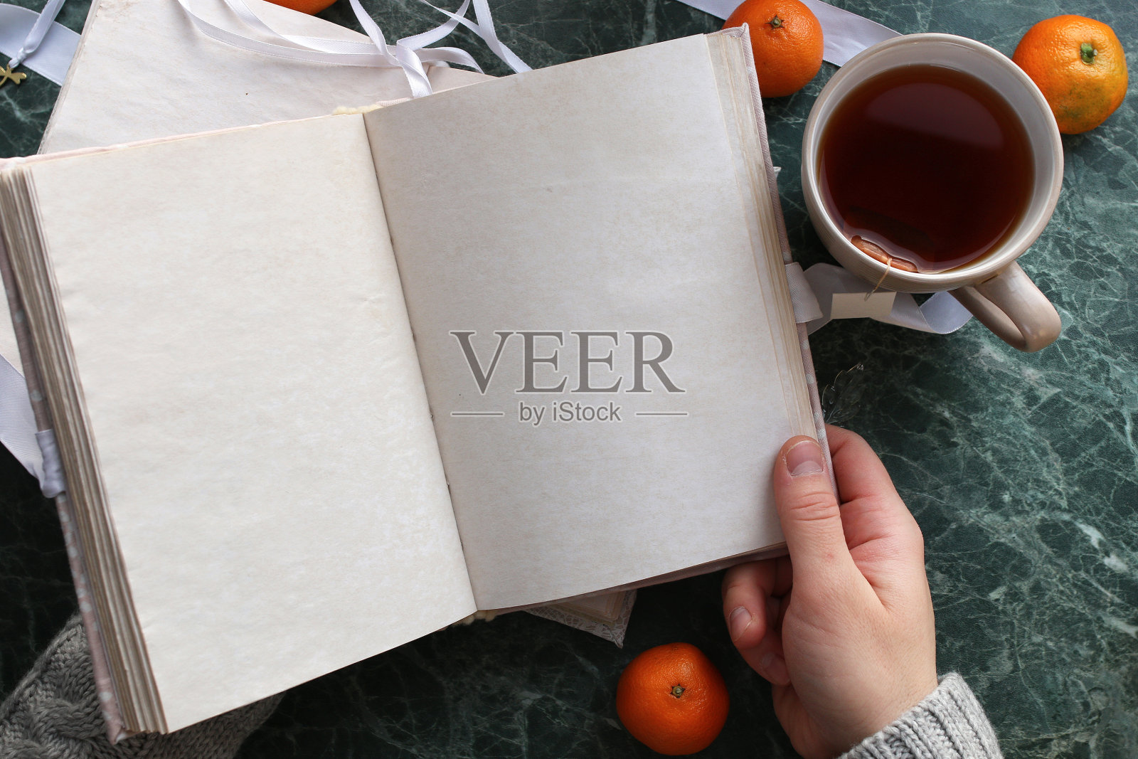 在绿色的大理石台面上，书页打开了一本古旧的书照片摄影图片