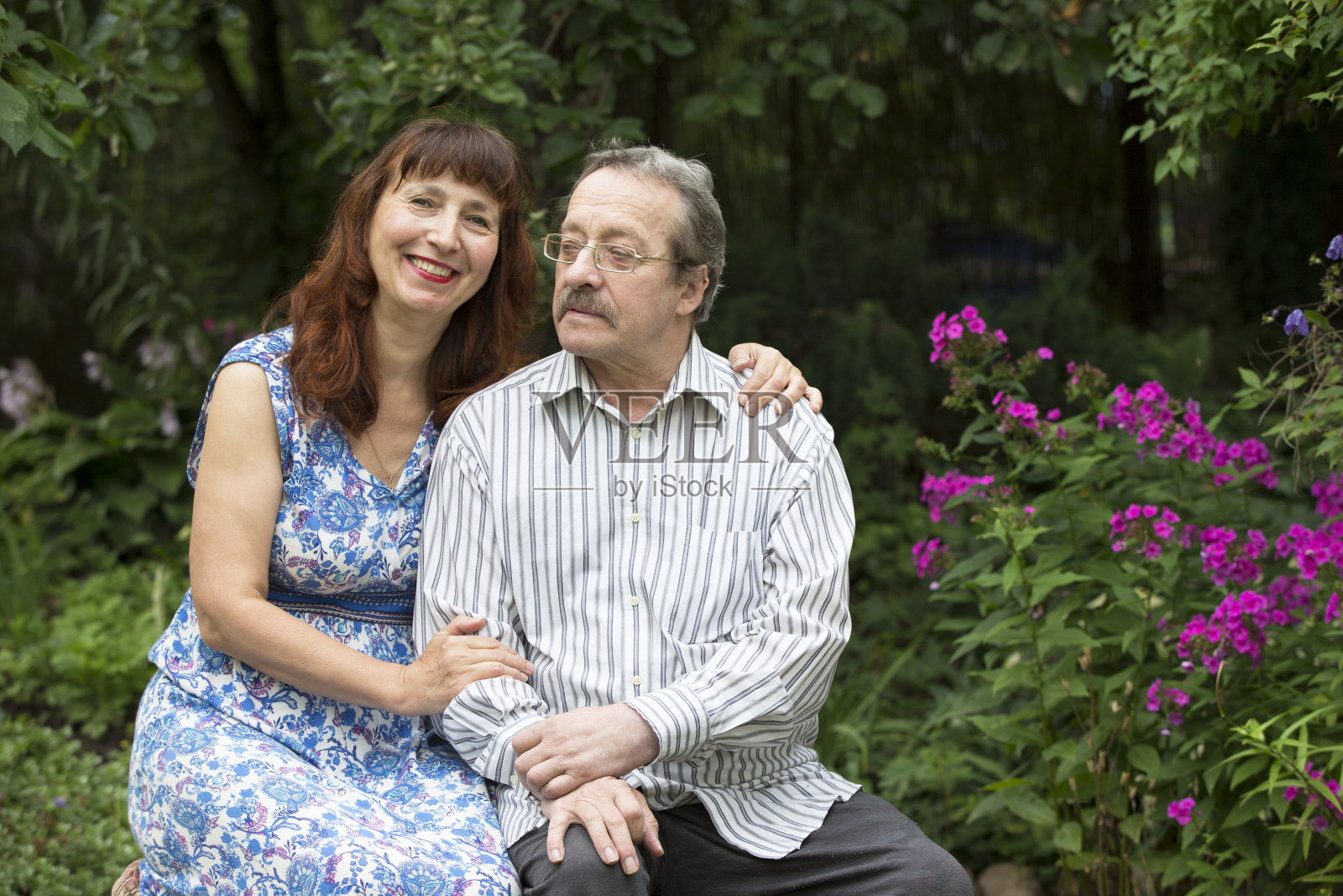 一对老年夫妇在夏天的花园里。丈夫和妻子照片摄影图片