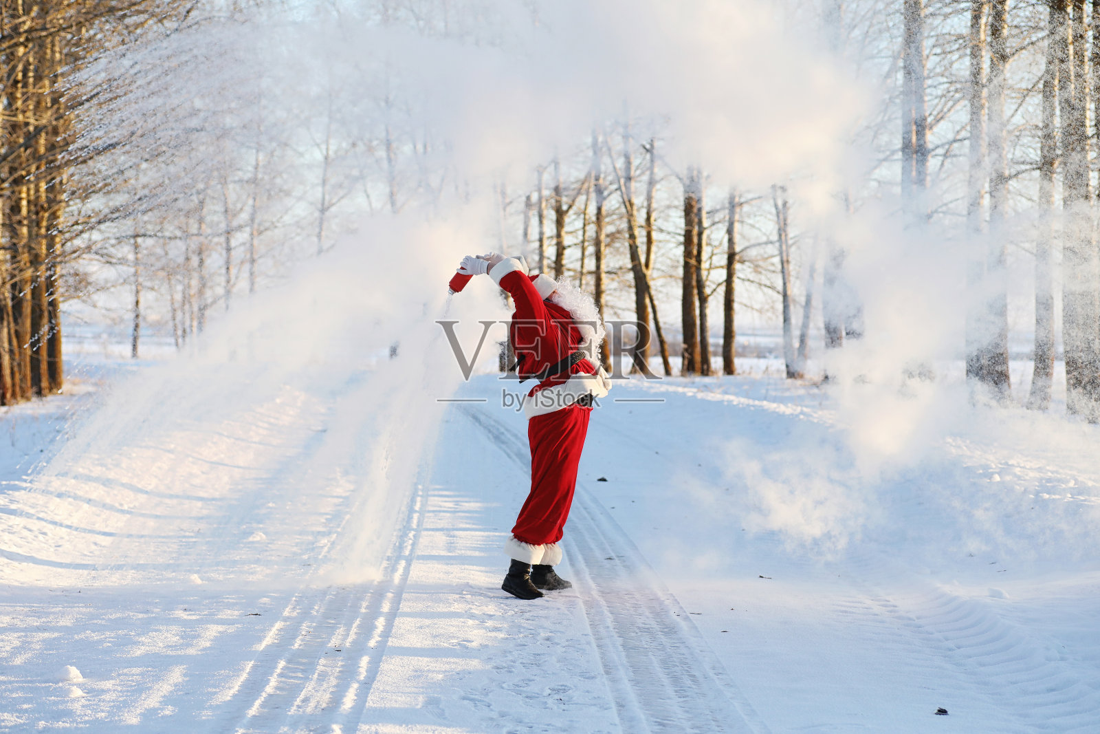 圣诞老人在冬天的田野里。圣诞老人神奇的雾正在田野里行走。圣诞老人在平安夜把礼物装在红色的袋子里送给孩子们。照片摄影图片