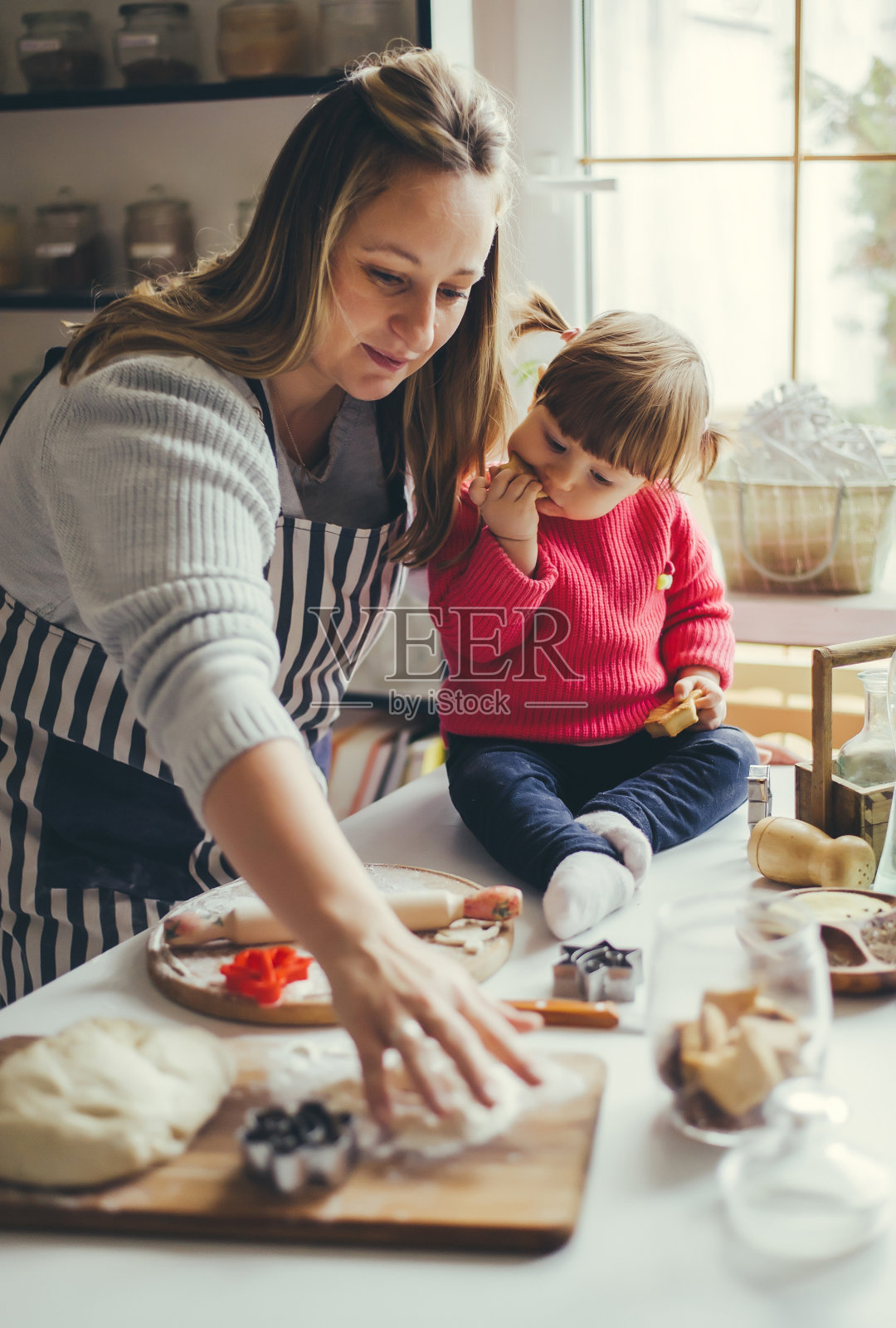 幸福的家庭在厨房。妈妈和女儿正在准备圣诞饼干。照片摄影图片