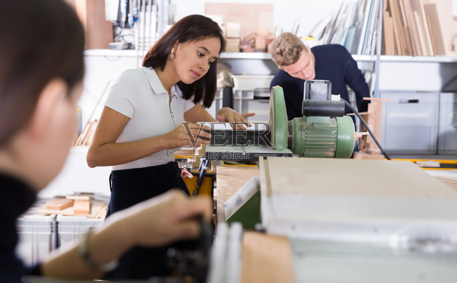 女学生在机器上打磨建筑模型的细节照片摄影图片