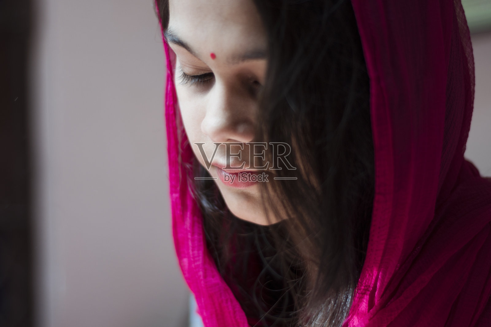 美丽的印度女孩在家里忙着手机照片摄影图片