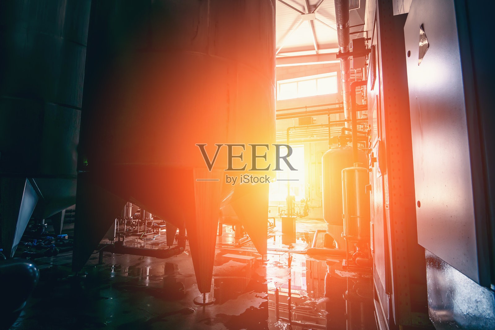 饮用水工厂生产，工业室内在阳光下。用于过滤和饮用水处理的大型金属罐照片摄影图片