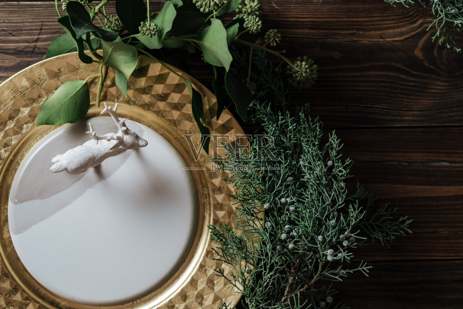 圣诞场所设置与金色色调和驯鹿雕像照片摄影图片