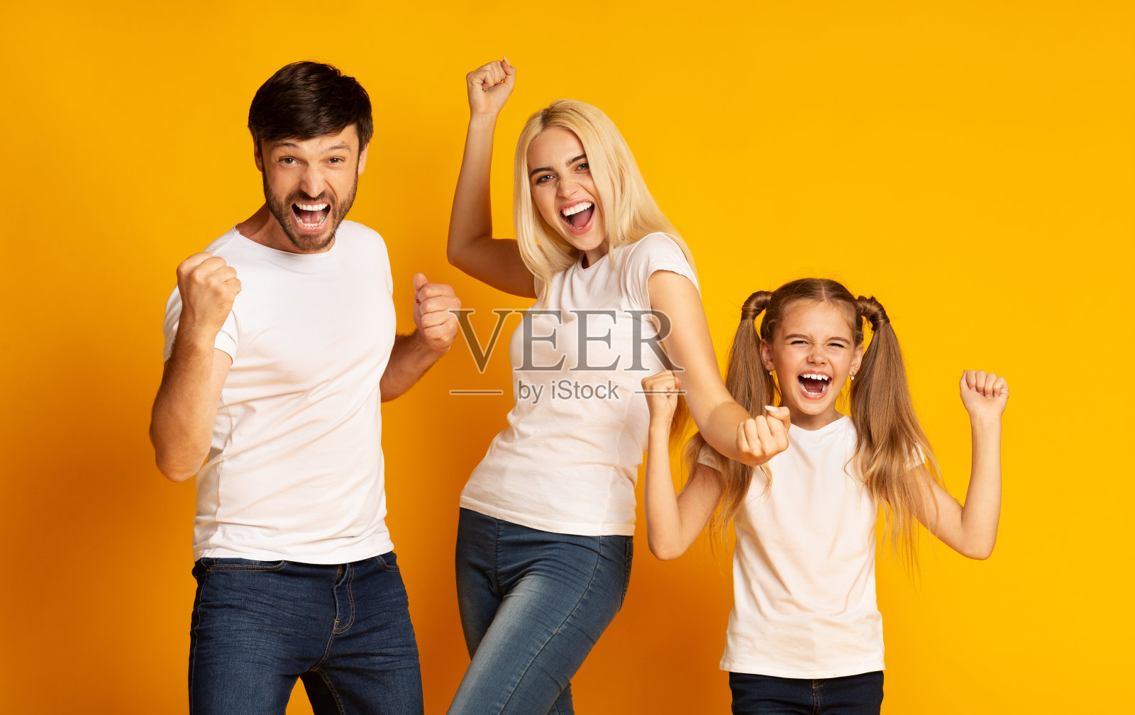 在黄色背景下，兴奋的家人挥舞着拳头表示同意照片摄影图片