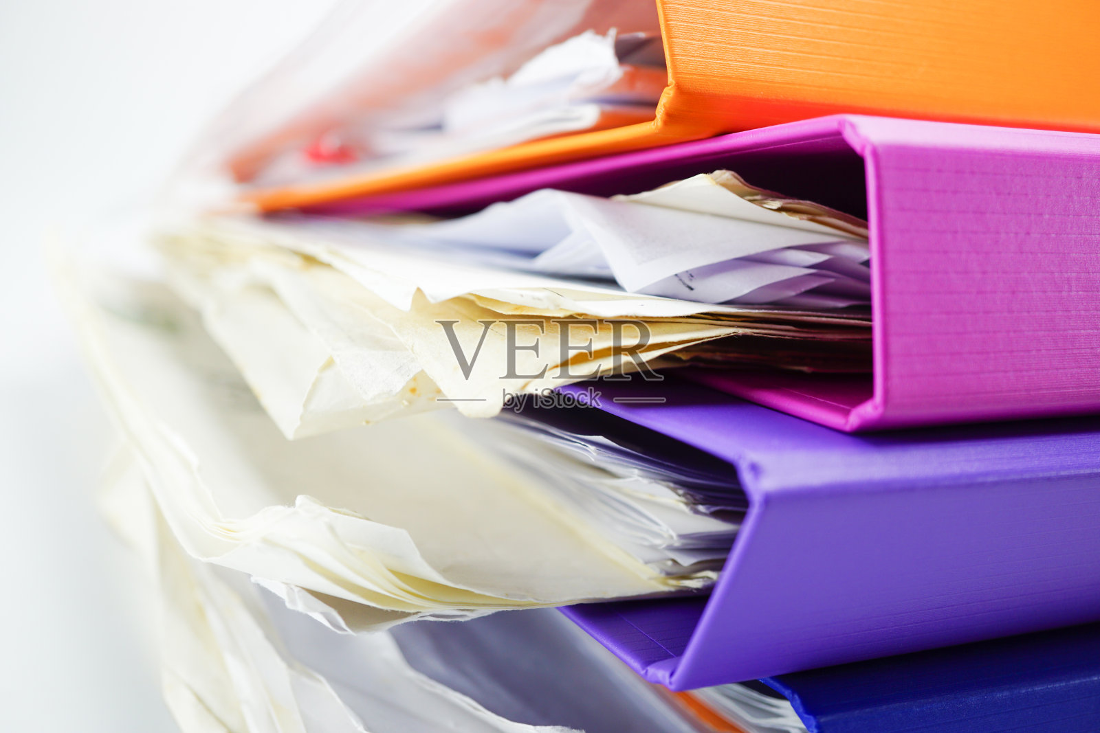 办公室桌子上多种颜色的文件夹和活页夹。照片摄影图片