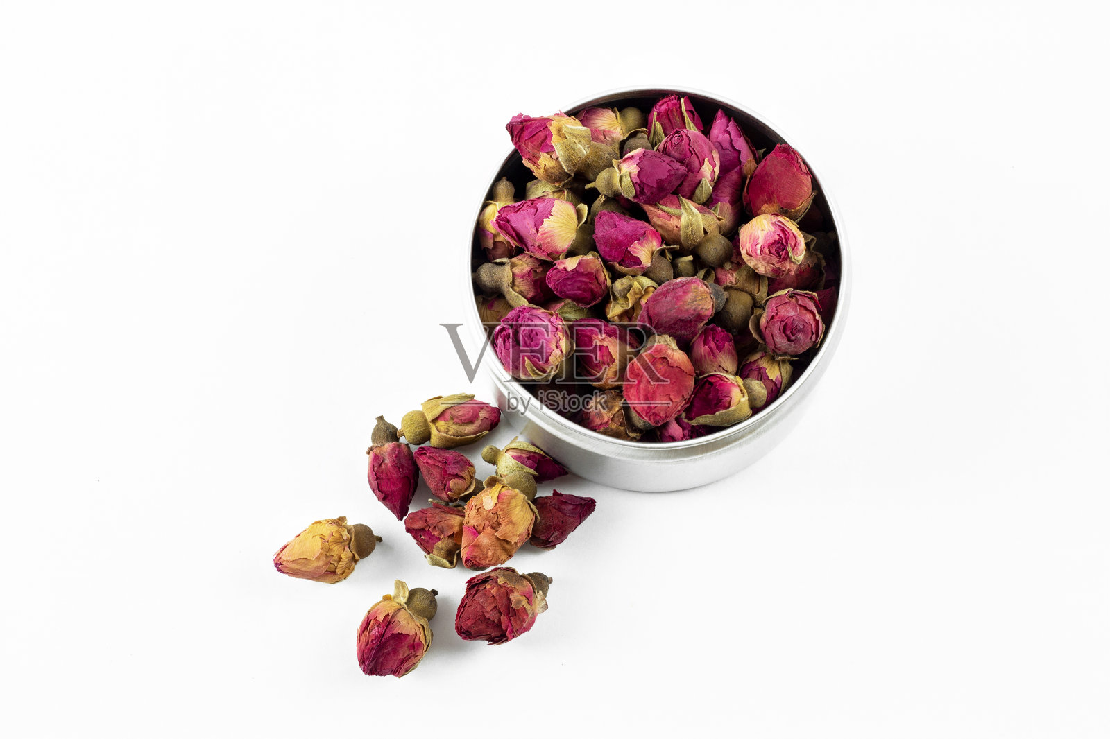红色和粉红色的玫瑰花蕾茶在金属容器，在白色的背景照片摄影图片