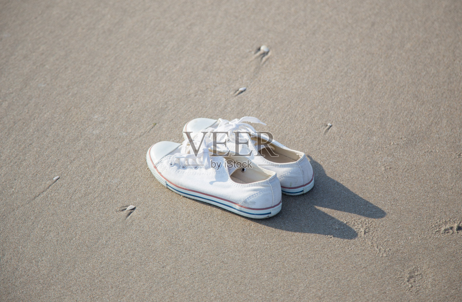 白色的鞋子在海滩上照片摄影图片