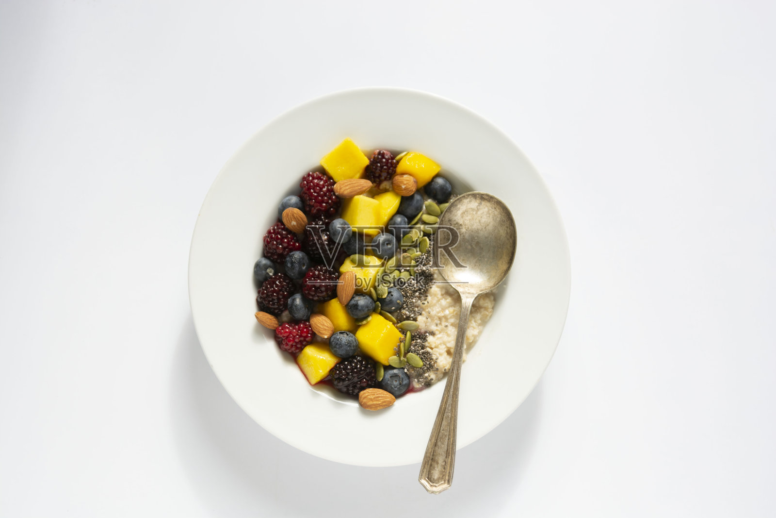 健康的早餐，燕麦粥，水果和坚果。蓝莓，芒果，南瓜子，坚果，咖啡杯。顶视图白色背景。23、清洁饮食、节食、减肥的观念照片摄影图片