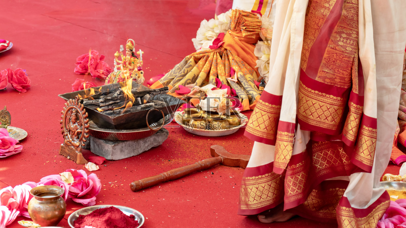 印度人的婚礼，传统民族仪式的婚礼装饰，在红地毯上燃烧，鲜花和神像照片摄影图片