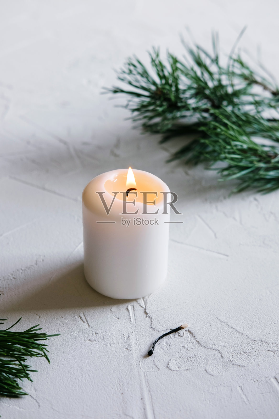 白色的蜡烛。圣诞节的心情。桌上燃着的蜡烛。照片摄影图片
