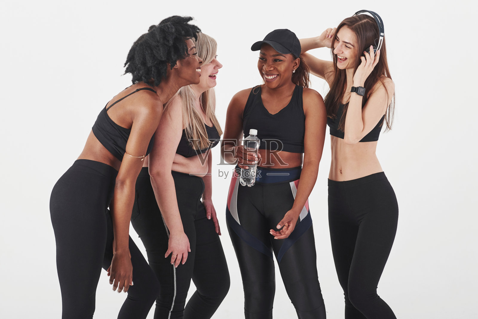 在开玩笑。一群多民族妇女站在工作室里，以白人为背景照片摄影图片