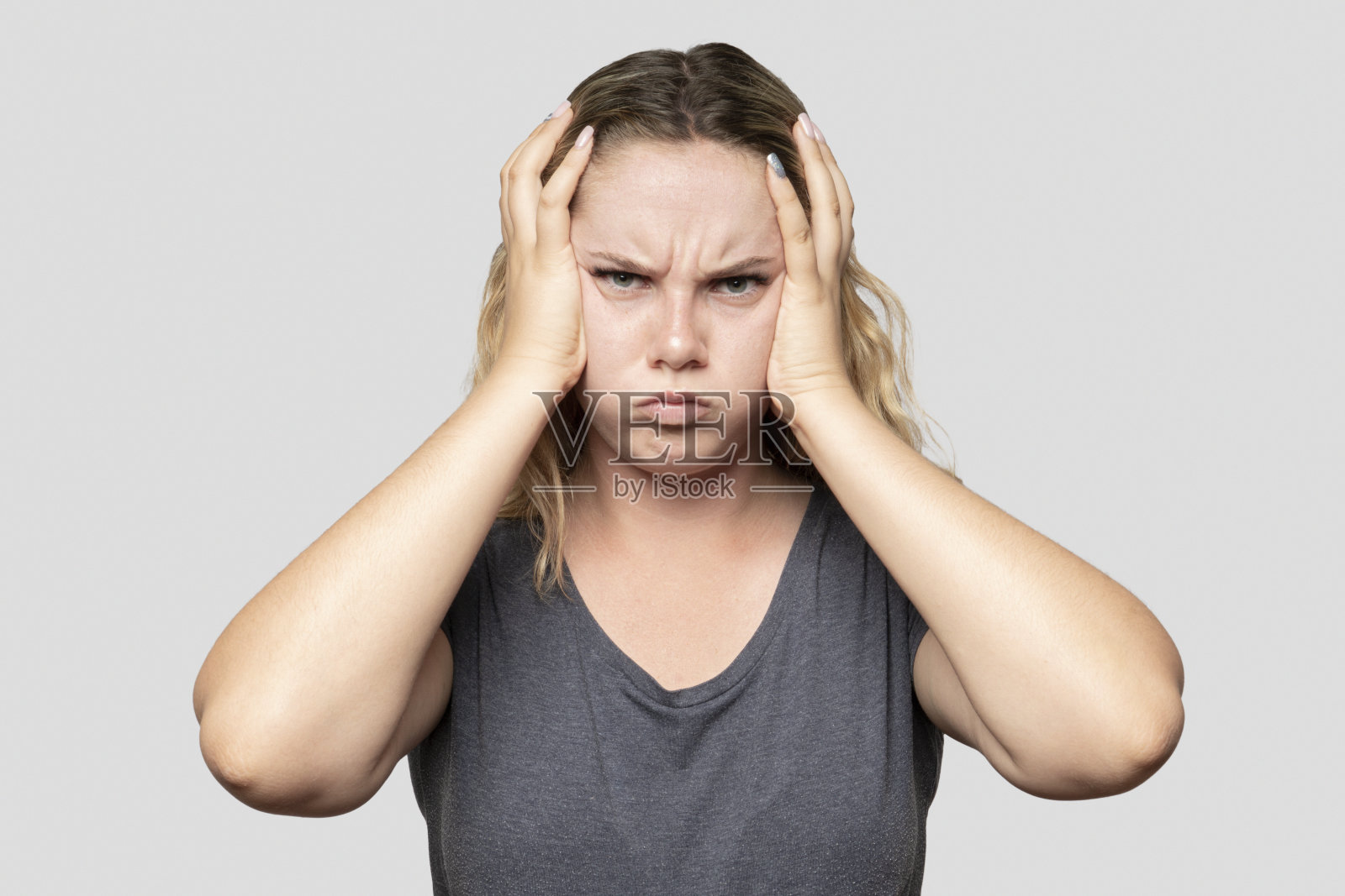 灰色背景下沮丧的年轻女子的肖像照片摄影图片