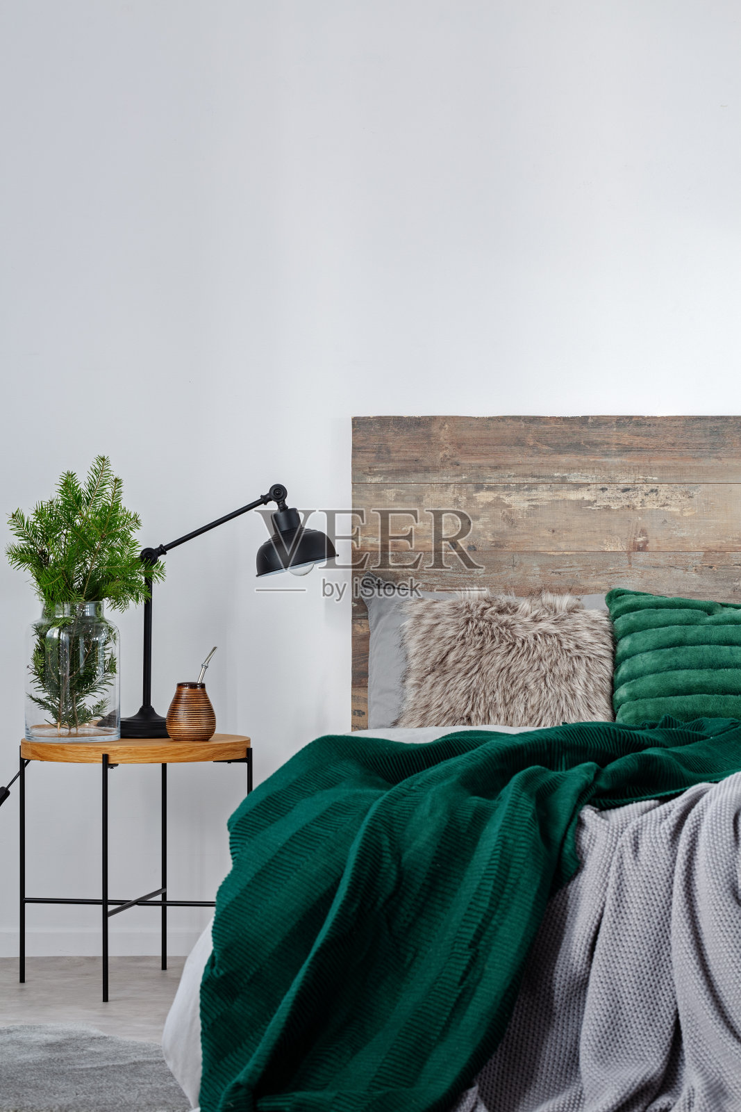 亚光耶尔巴，云杉玻璃花瓶和黑色工业灯放在床边的木制床头柜上照片摄影图片