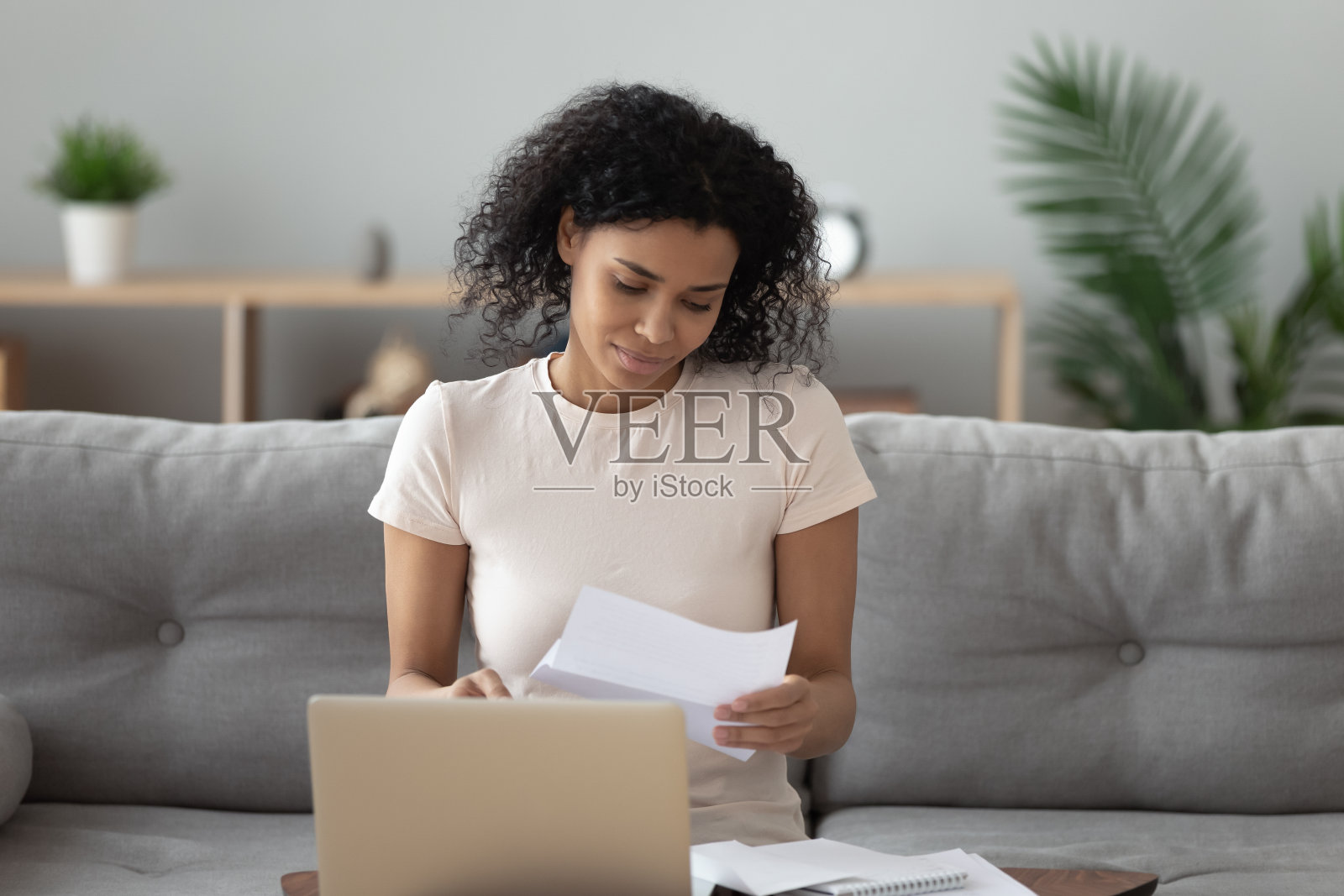 一位非裔美国妇女正在看一封信，信中有好消息照片摄影图片