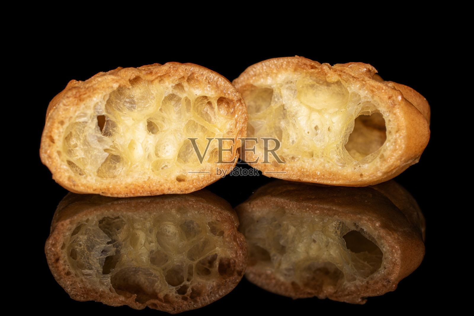 在黑色玻璃上分离出金黄色烘烤的异形果照片摄影图片