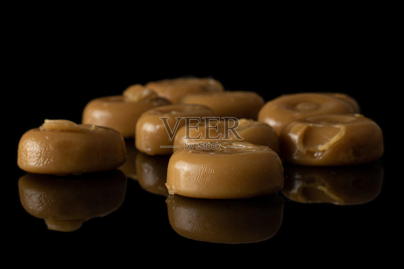 棕色焦糖分离在黑色玻璃上照片摄影图片