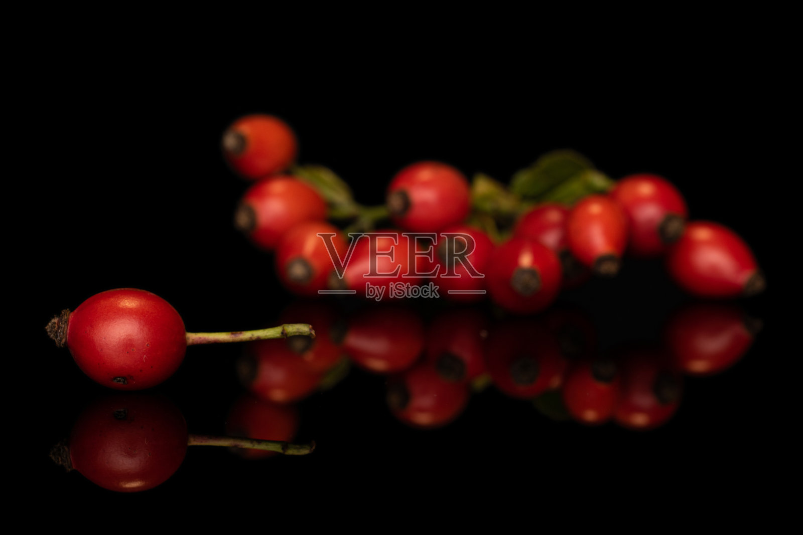 新鲜的红色玫瑰果孤立在黑色玻璃上照片摄影图片