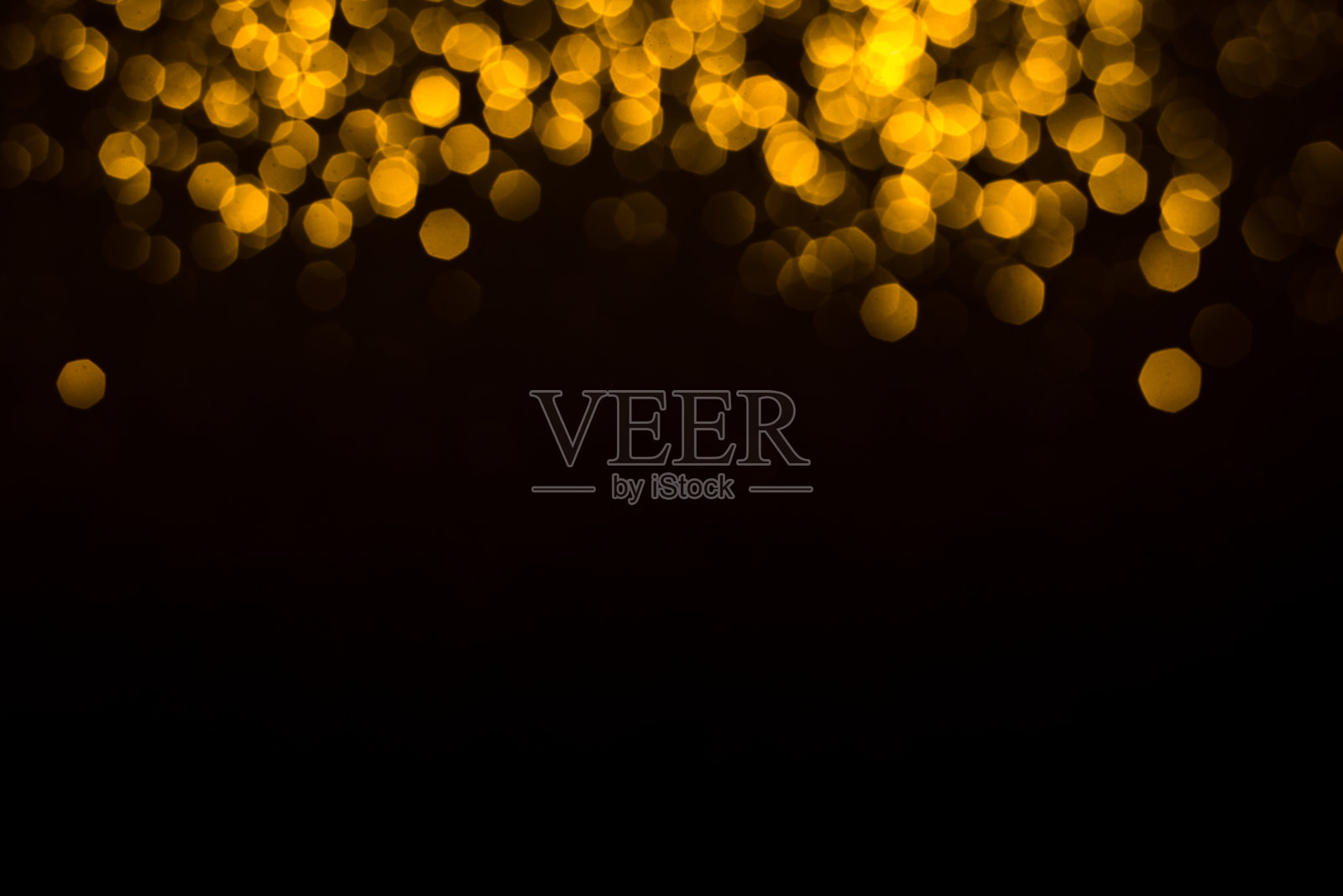 黑色背景上的金色抽象散景。照片摄影图片