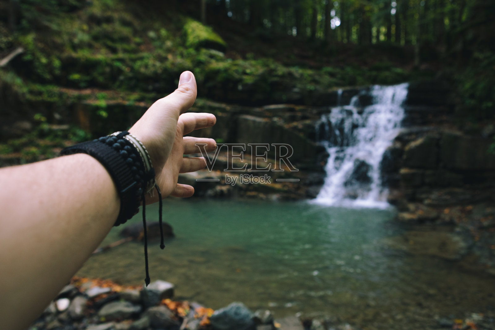 第一个人看男人的手显示瀑布徒步概念照片摄影图片