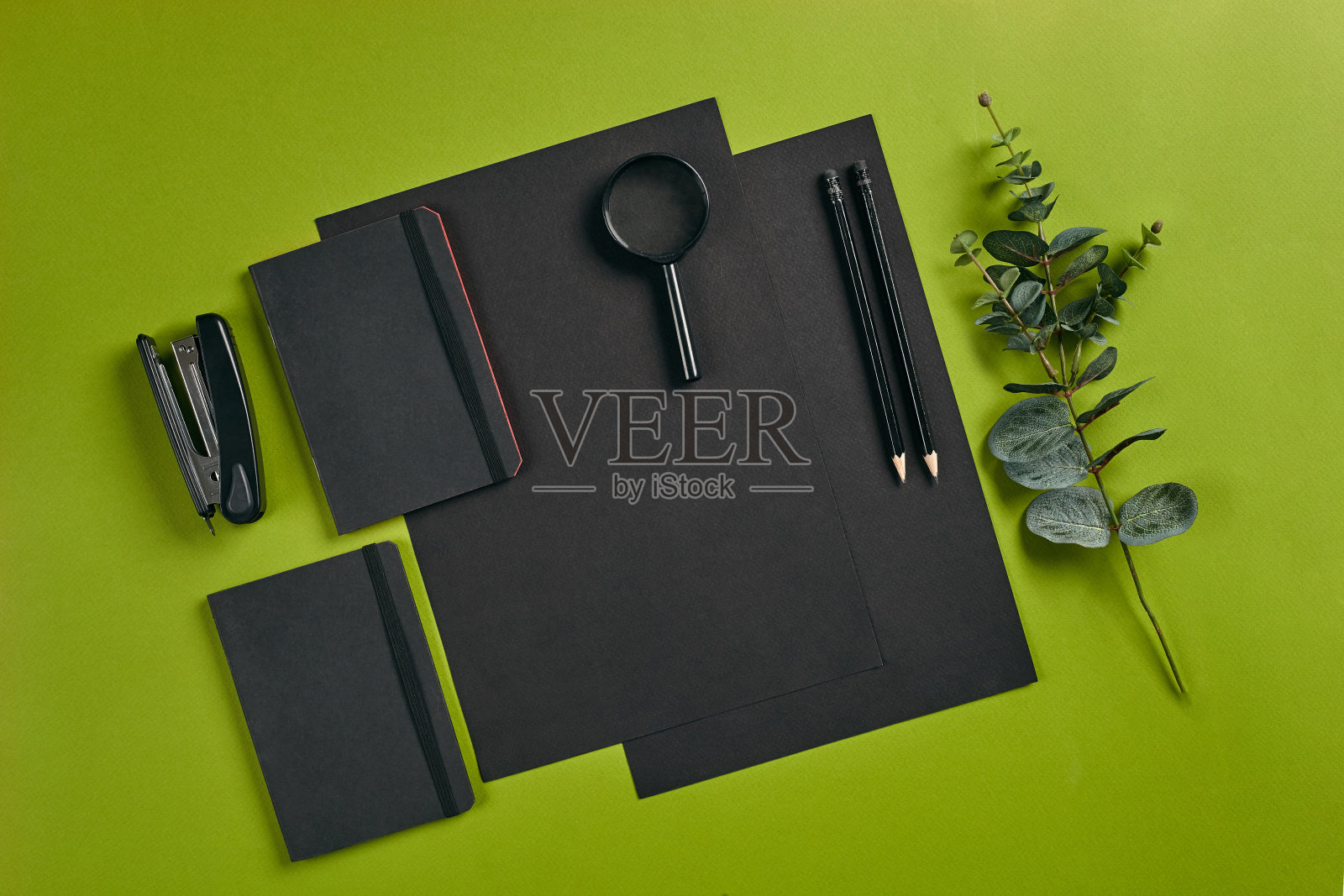 俯视图集中使用不同的办公设备，用品，文具。绿色背景与复制空间。教育、工作场所的概念。特写镜头照片摄影图片